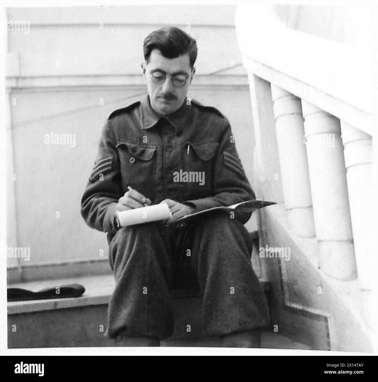 Sgt. Baker schreibt Notizen für seinen nächsten Vortrag in Nordafrika als Teil der Observer Story No.61 unter Aufsicht der British Army. Stockfoto
