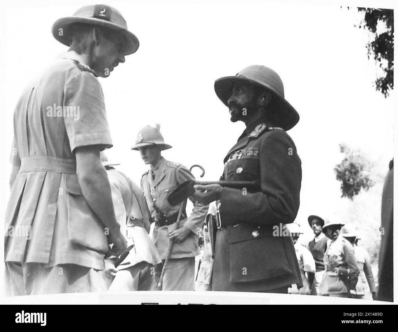 Der Kaiser von Abessinien geht und unterhält sich mit britischen Offizieren der Militärmission, während er den nationalen Standard entwickelt. Stockfoto