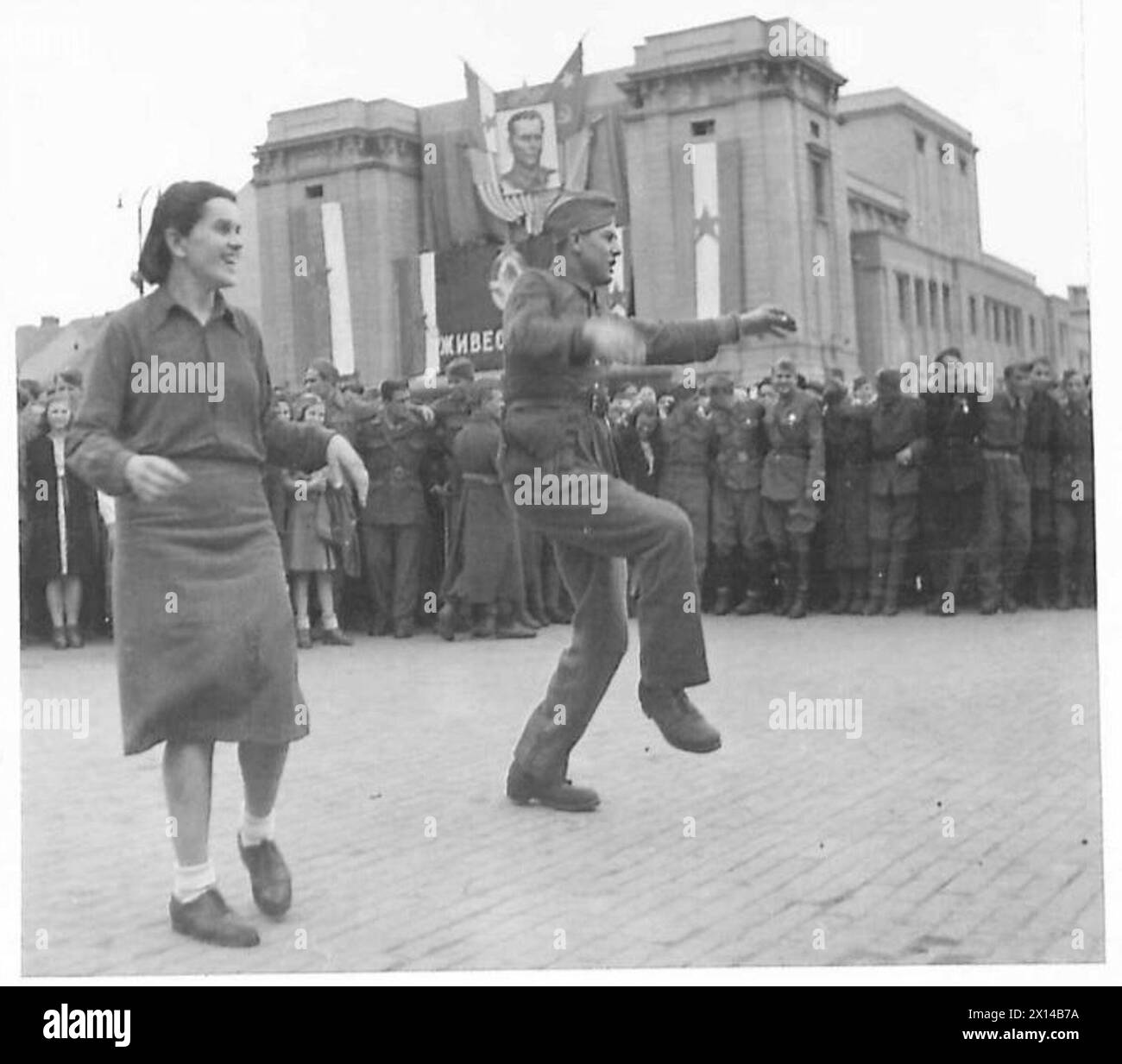Menschenmassen in Jugoslawien mit Fahnen und Bannern, darunter ein großer Union Jack am 27. März, britische Armee. Stockfoto