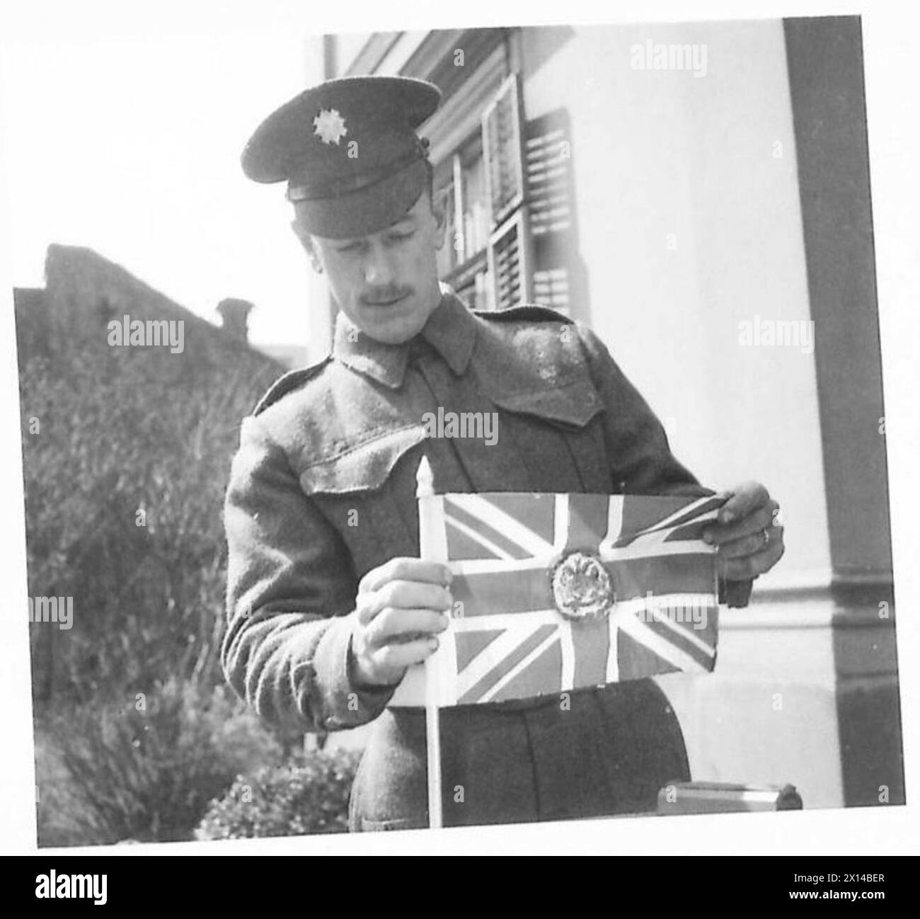 Ein Bodyguard und Fahrer, J. Adams aus Manchester, bringt die Flagge des Botschafters an, bevor er die britische Botschaft in Belgrad zu einem offiziellen Besuch verlässt. Stockfoto