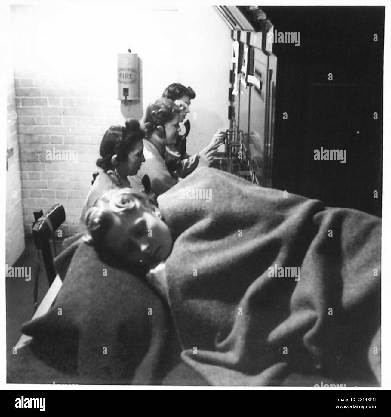 ATS-Telefonisten arbeiten in drei Stunden an der Zentrale; einer ruht sich aus, während andere ihre Aufgaben fortsetzen. Stockfoto