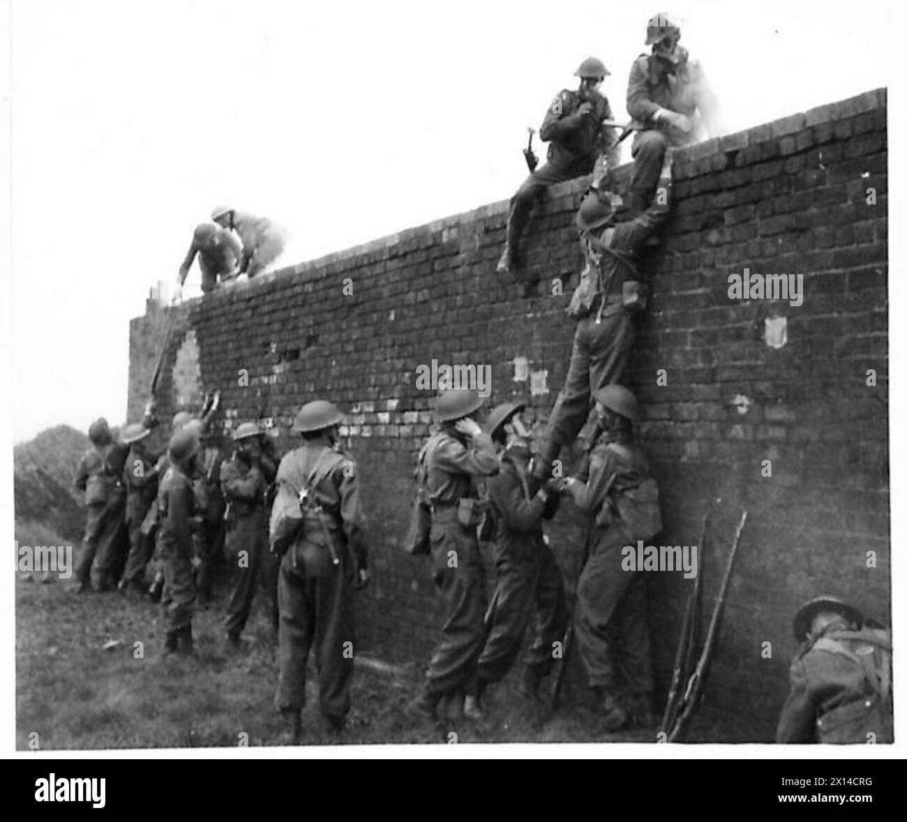 Die Hauswächter klettern mit Rauchschirmen auf eine Wand während einer Demonstration von Stadtkämpfen unter Beobachtung von Major General Johnson Stockfoto