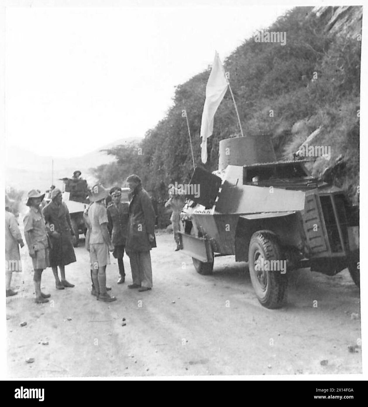 Ein italienischer gepanzerter Wagen mit weißer Flagge tritt in Kismayu und Mogadischu, italienischer Somaliland, für den Transport italienischer Offiziere nach Harrar auf. Stockfoto