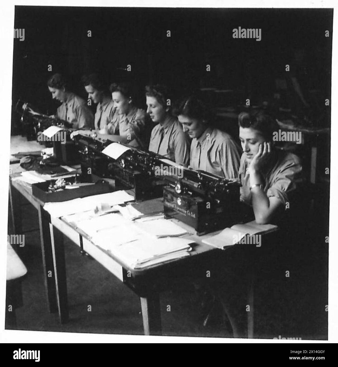 MIT TOMMYS KONTEN ZU TUN - Eine Reihe von Schreibmaschinen bei der Arbeit. Auf der rechten Seite befinden sich Ptes. Jean und Margaret McCallum, Zwillingssisteis von Ilford British Army Stockfoto