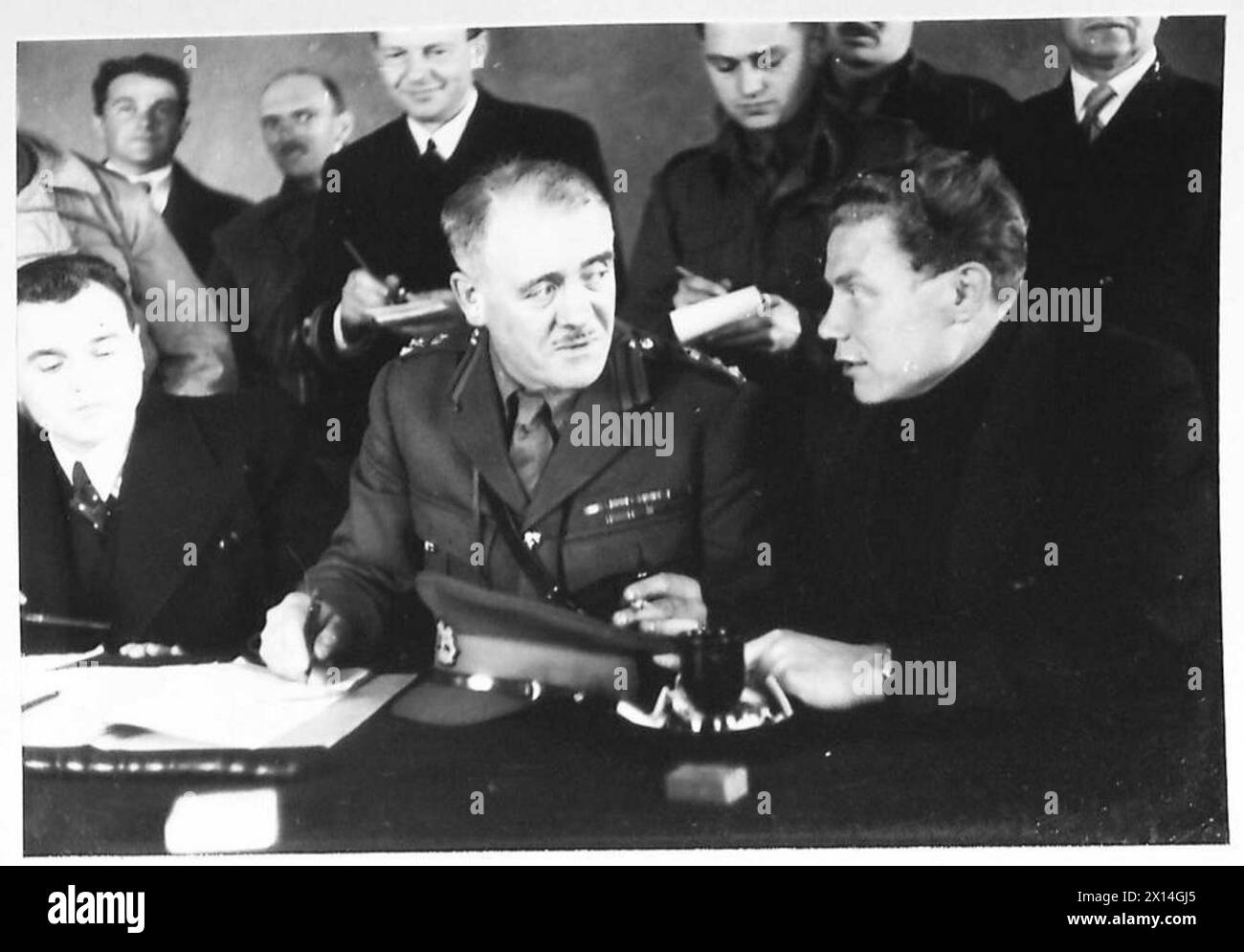 Brigadier Potts koordiniert sich mit Vertretern der russischen Regierung und dem Leiter einer Siedlung, um die Evakuierung russischer Bewohner während des Überfalls in Spitzbergen zu veranlassen, wobei die militärische Koordinierung und der Katastrophenschutz hervorgehoben werden. Stockfoto