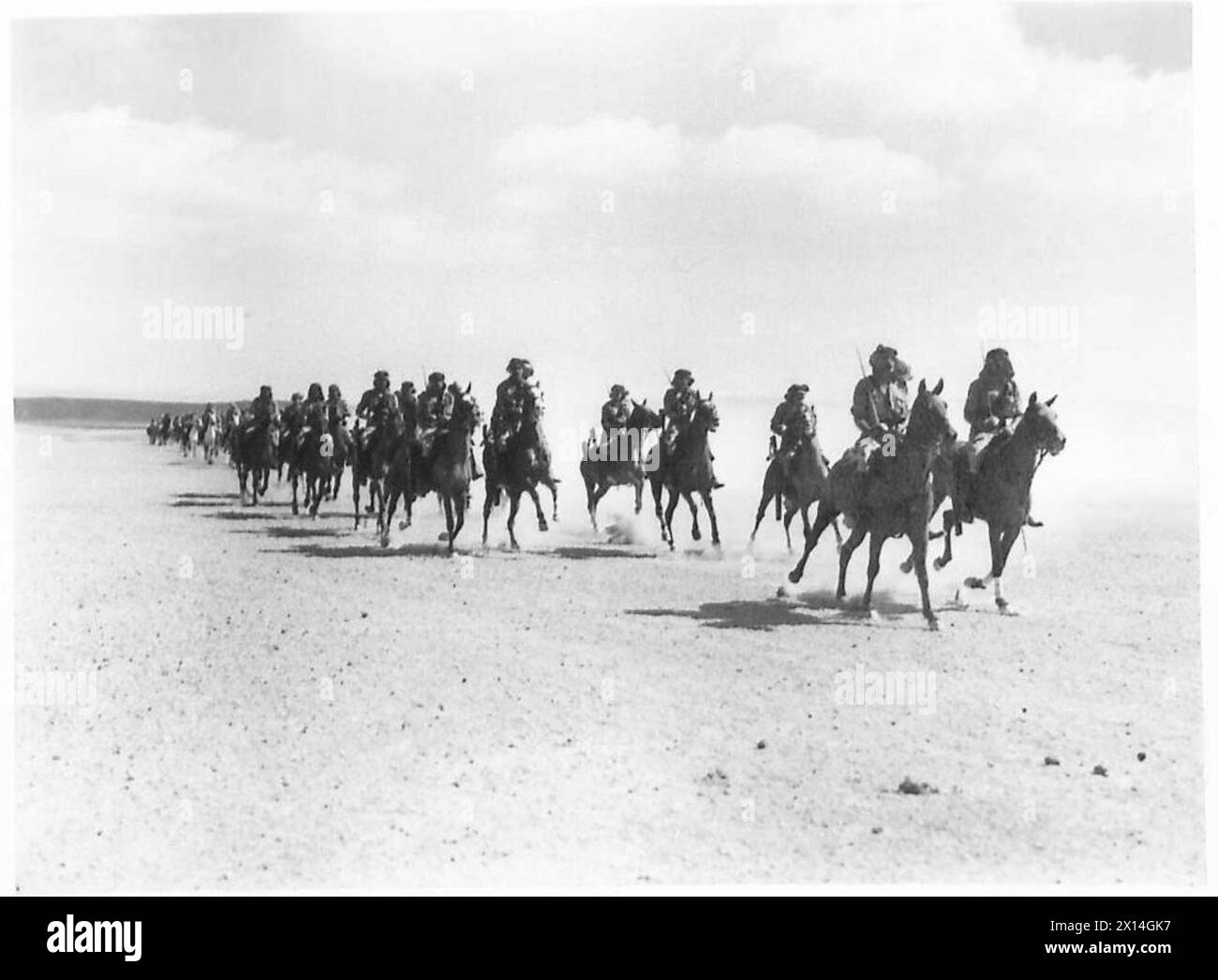 Die Truppen der Transjordan Frontier Force der britischen Armee galoppieren zu Pferd durch das offene Land und zeigen Kavallerie-Operationen und Mobilitätstraining. Stockfoto
