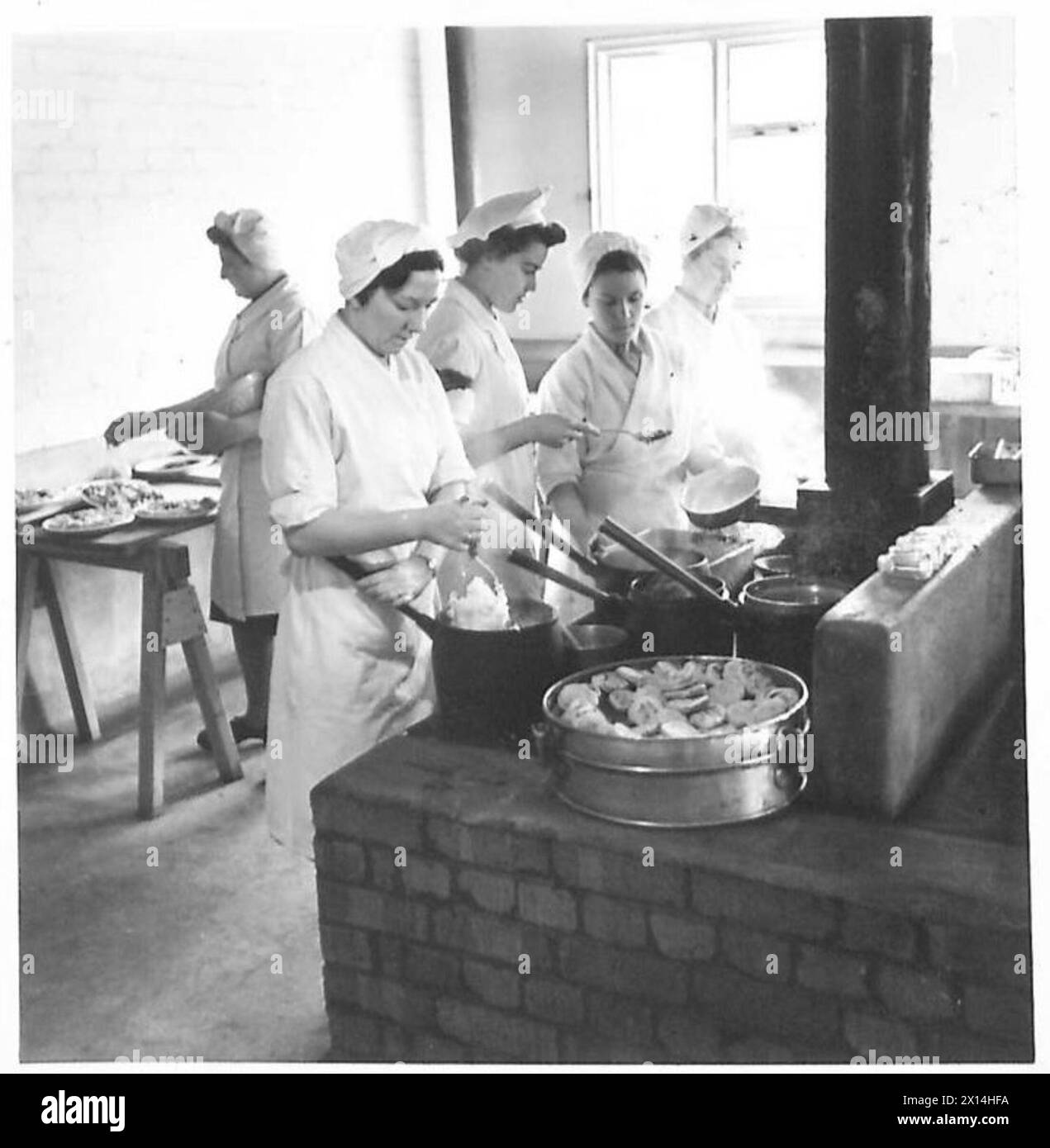 Ein Sergeant inspiziert die Lebensmittelzubereitung an der ATS School of Cookery und hebt die militärische kulinarische Ausbildung und das Küchenmanagement hervor. Stockfoto
