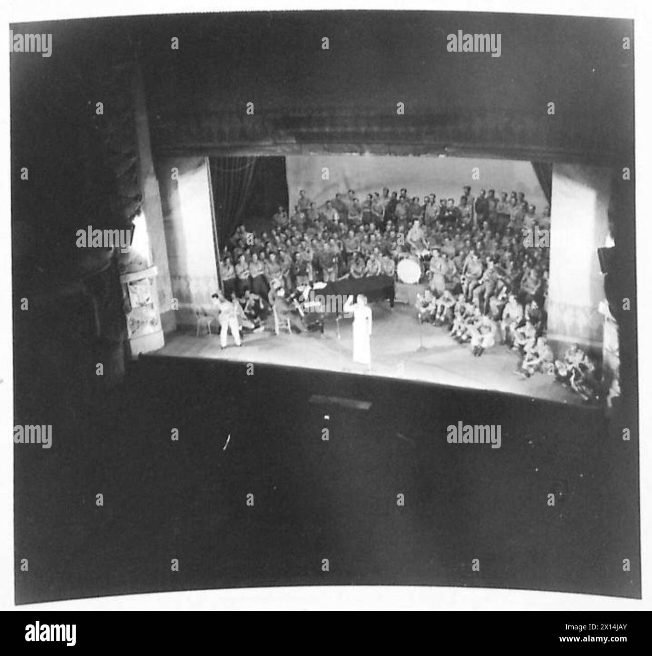 Gracie Fields tritt in Nordafrika auf, wobei sich das Publikum vom Auditorium bis zur Bühne für eine Sendung erstreckt. Stockfoto Gracie Fields tritt in Nordafrika auf, wobei sich das Publikum vom Auditorium bis zur Bühne für eine Sendung erstreckt. Stockfoto