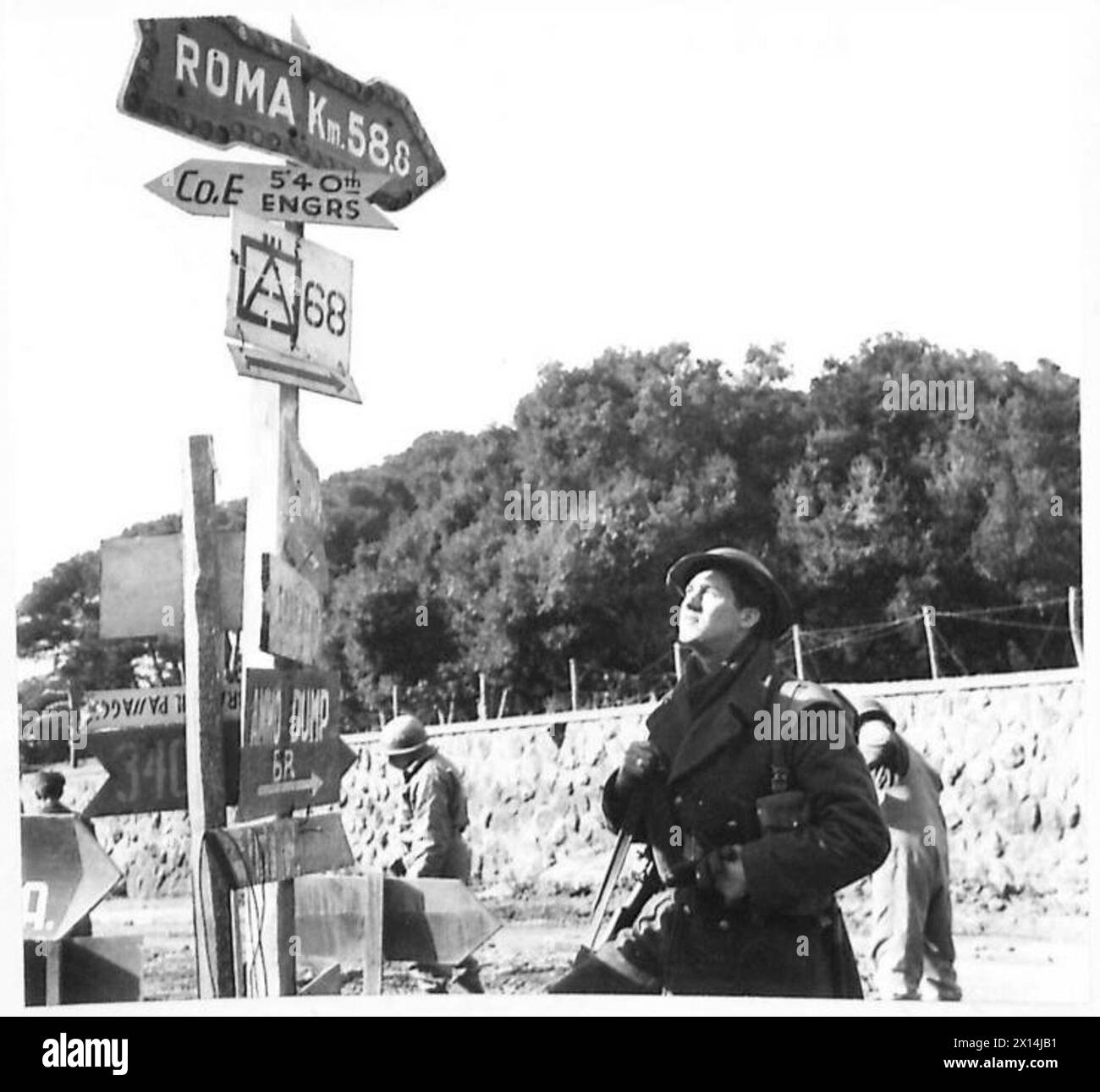 Pte. Johnson, eine Verstärkung der Queens, hält an einem Wegweiser mit der Aufschrift „Roma km 58.6“ am Anzio-Brückenkopf der britischen Fünften Armee in Italien. Stockfoto