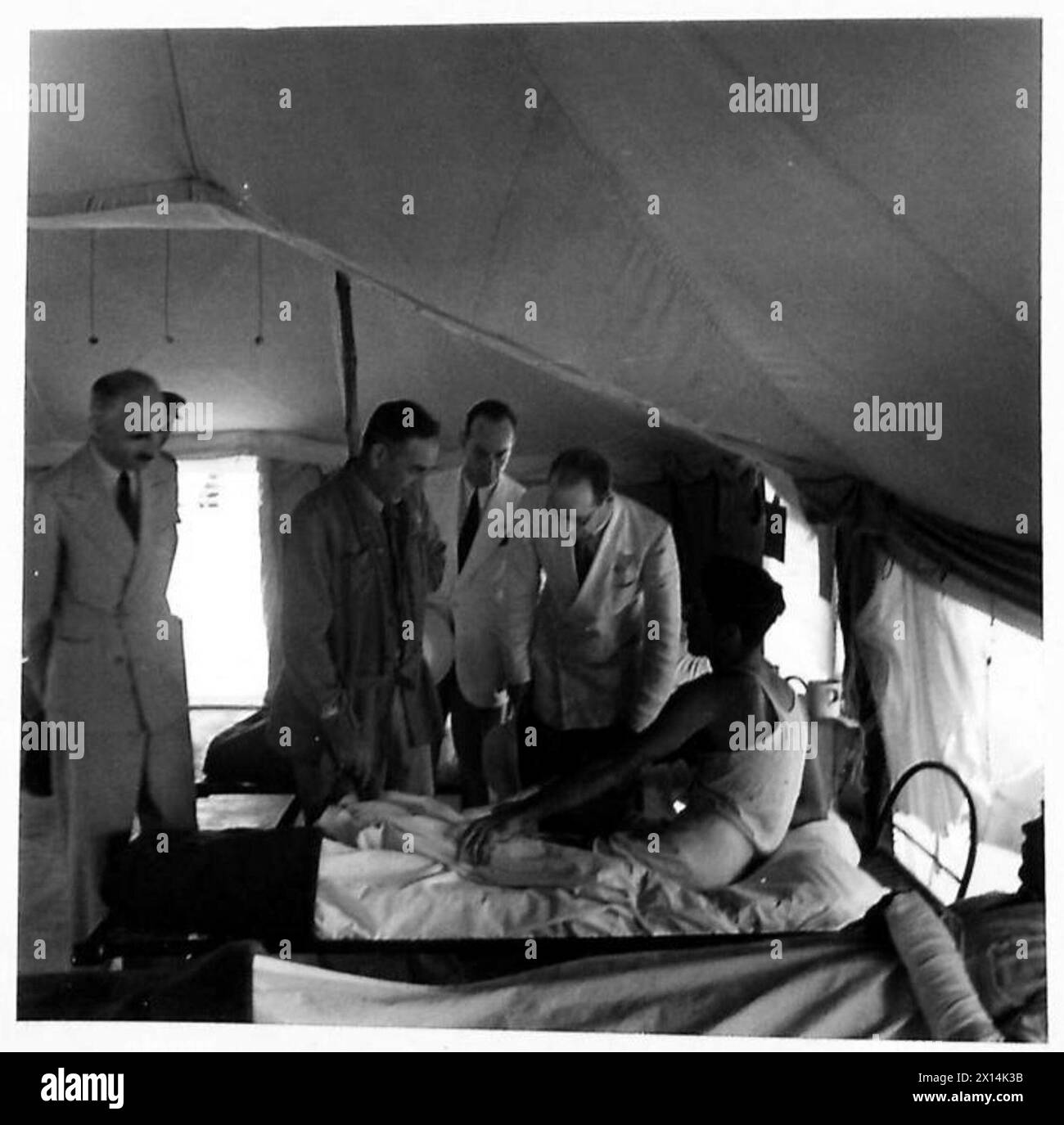 BESUCH DES INTERNATIONALEN ROTEN-KREUZ-KOMITEES IM P.O.W.-LAGER UND KRANKENHAUS IM NAHEN OSTEN (19. GENERAL) - IN EINER DER KRIEGSGEFANGENENKRANKENHAUSSTATIONEN. Auf der linken Seite sind Dr. George Vaucher und Mr. J. Duchosal und Mr. De Haller (in weißen Mänteln) British Army Stockfoto