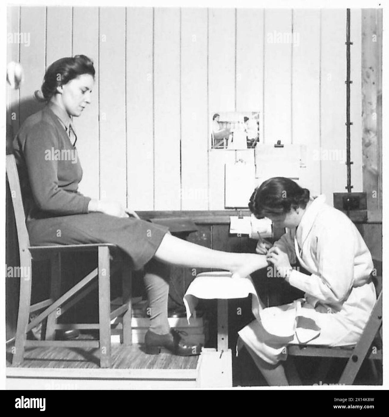 EIN ATS-CHIROPODIST - CPL. Molile Mather, eine ATS-Chiropodistin, die sich um eine Hilfskräfte der britischen Armee kümmert Stockfoto