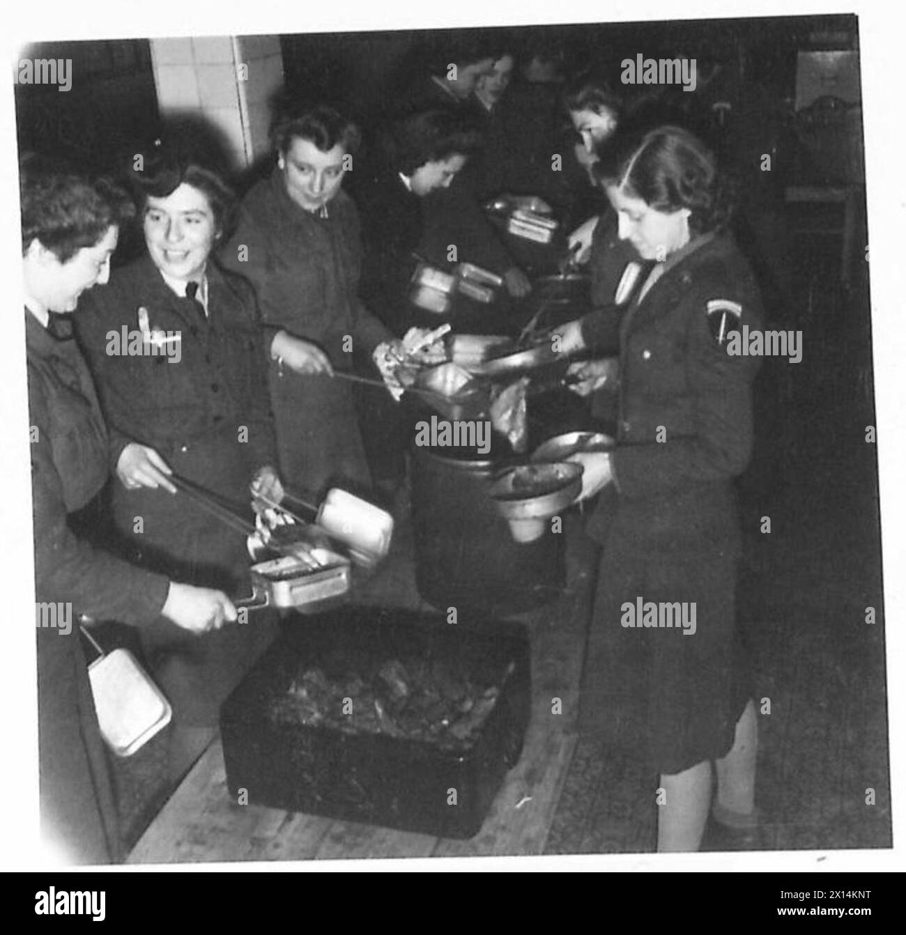 Mitglieder von W.R.N.S., A.T.S., W.A.A.F., und W.A.C.S. essen zusammen in einem Saal, während sie mit S.H.A.E.F. servieren Stockfoto