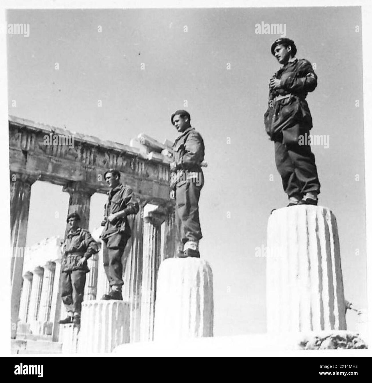 Britische Fallschirmjäger beobachten das Hissen der griechischen Flagge am Parthenon von Aussichtspunkten auf alten Säulen während einer Regierungszeremonie. Stockfoto
