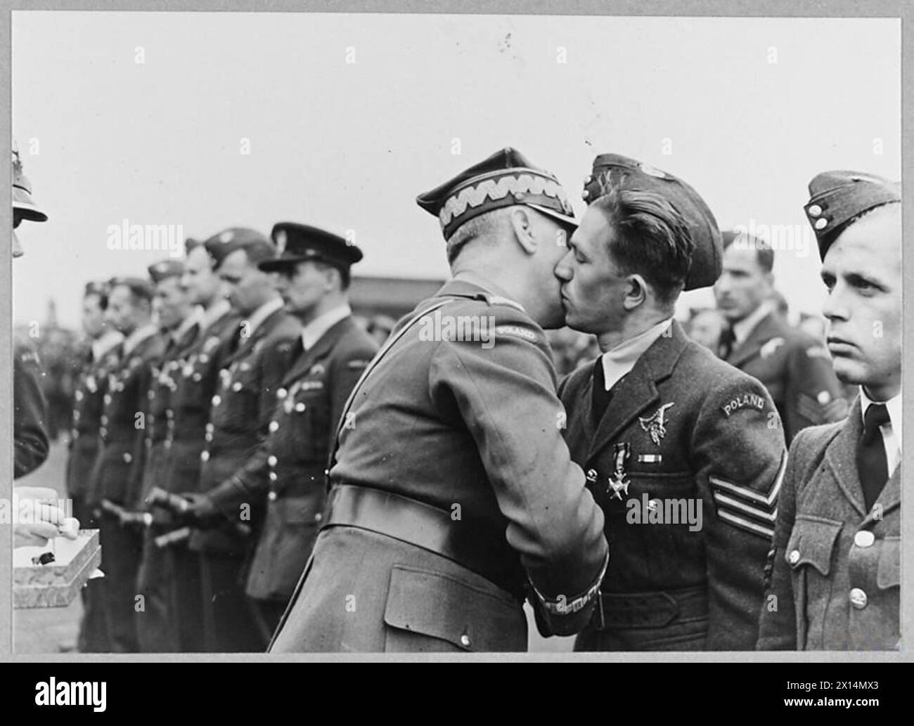 Der neue polnische Luftwaffenstandard, der unter sowjetischer Besatzung in Wilno geschaffen und über Schweden nach Großbritannien geschmuggelt wurde, wird am 16. Juli 1941 auf der RAF Swinderby präsentiert, wo General Władysław Sikorski die NCOs mit der Virtuti-Militari-Medaille verziert. Stockfoto