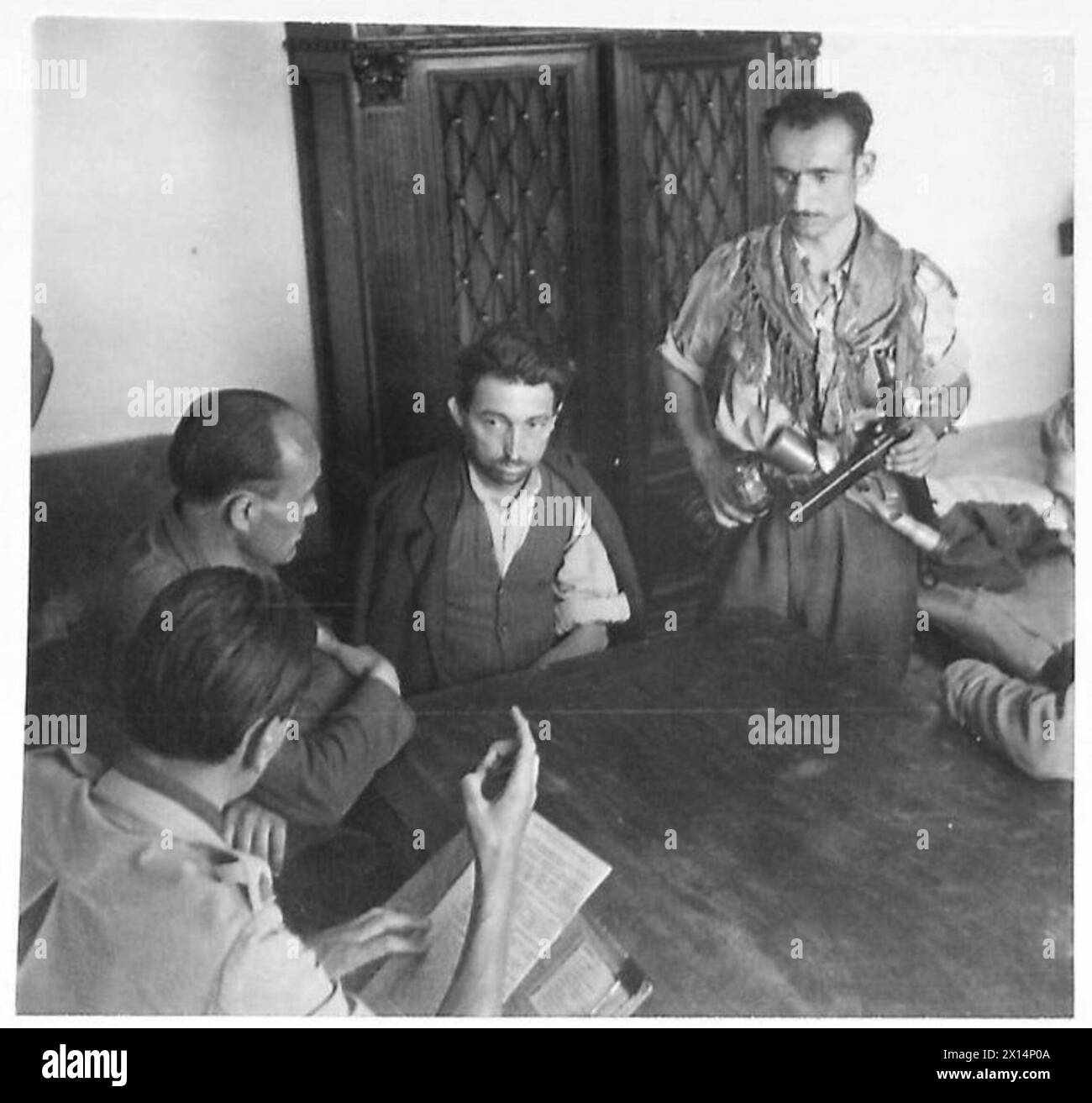 Bidini Guino, der als Faschist identifiziert wurde, wird in Einem Staffelquartier verhört, während Major Quin auf ihn während der Operationen der britischen Armee in Nordafrika, Sizilien, Italien, dem Balkan und Österreich von 1942 bis 1946 verweist. Stockfoto