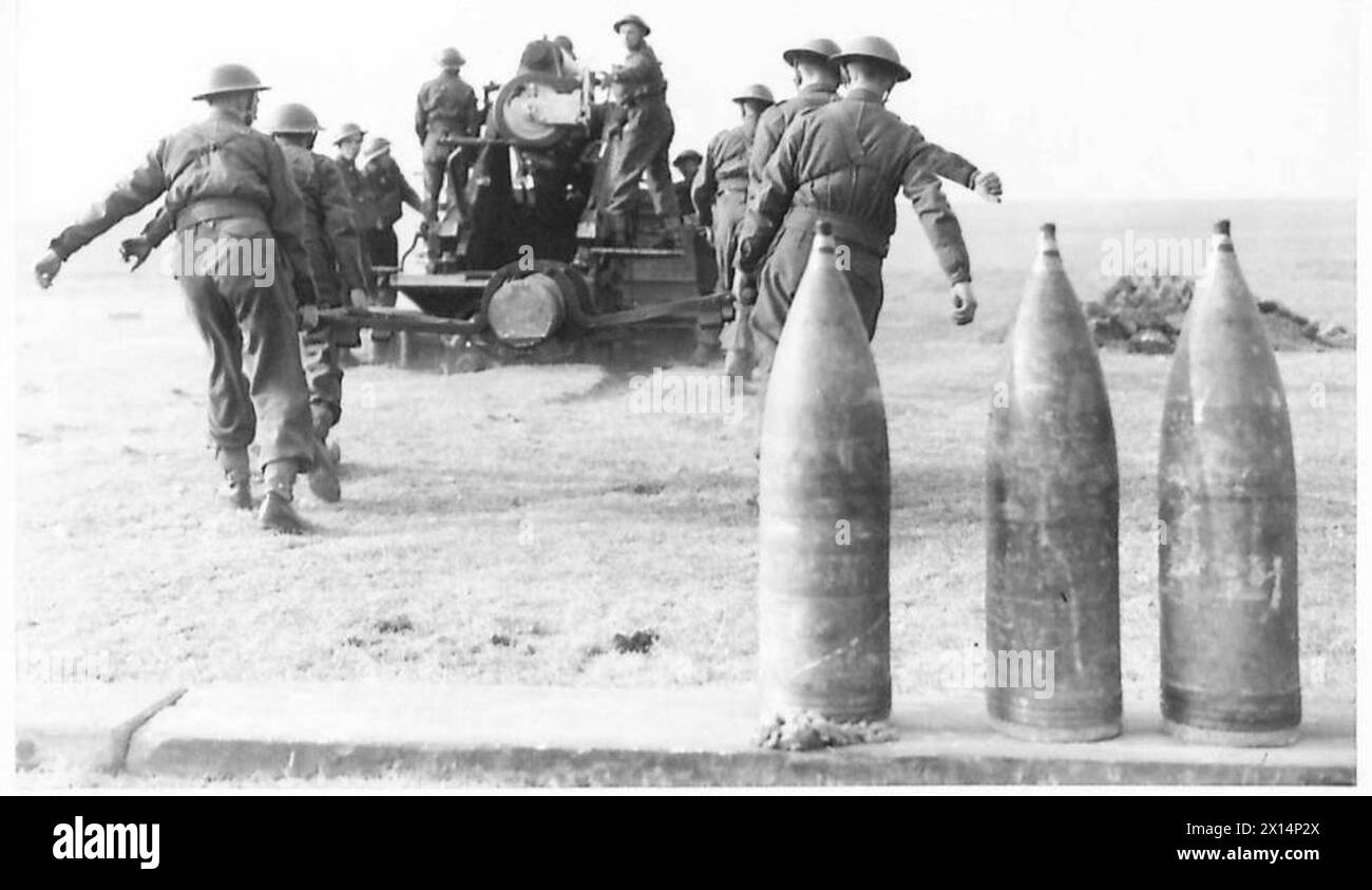 Foto, das Personal zeigt, das eine Granate zu einem großen Artilleriegewehr trägt, das von der britischen Armee betrieben wird. Stockfoto