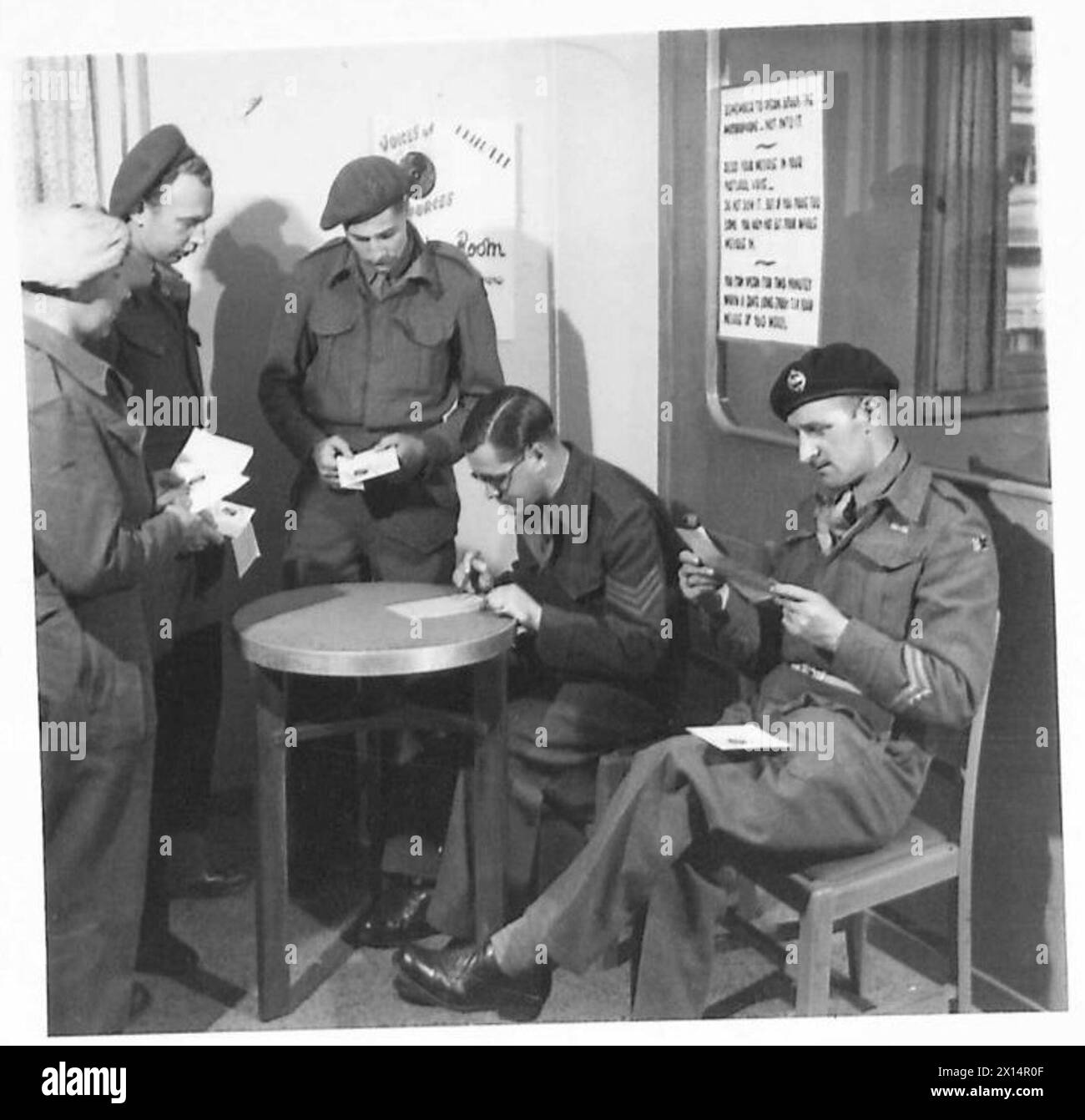 In Italien probt Ted Jellyman seine gecheckte Botschaft für „Voices of the Forces“, während der N.C.O. die Nachrichten der Gruppe überwacht. Stockfoto