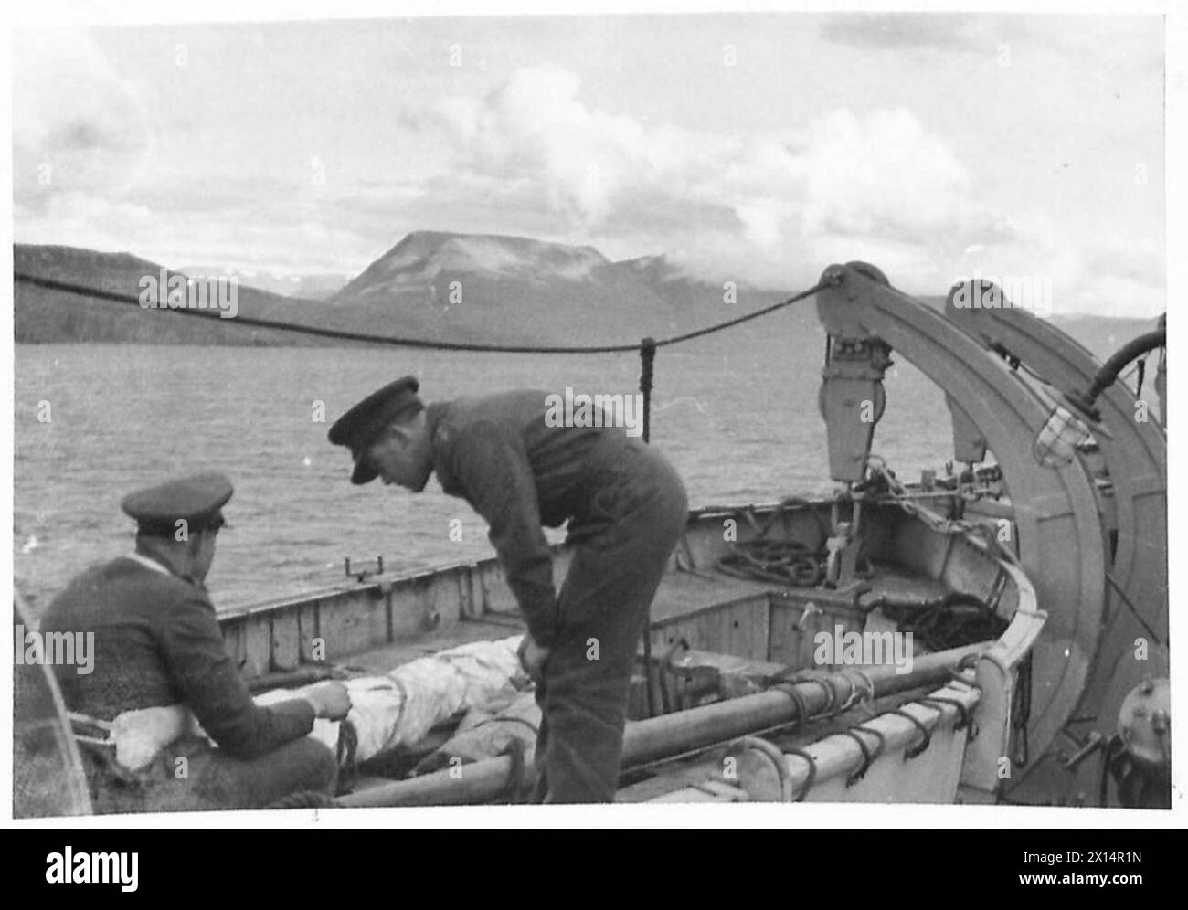 Britische und kanadische Truppen operieren in Island, wobei die typische isländische Küstenlandschaft von einem Schiff entlang der Nordwestküste während militärischer Aktivitäten beobachtet wird. Stockfoto