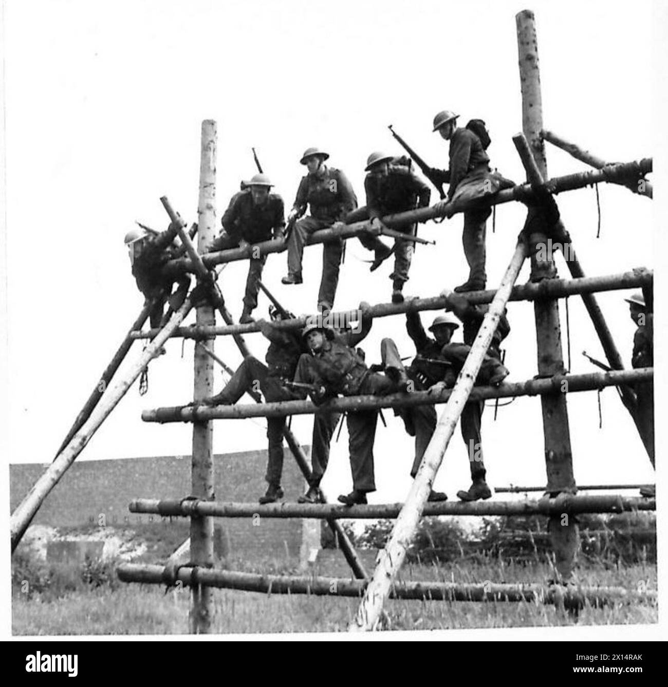 Soldaten der britischen Armee in voller Schlachtordnung klettern während einer militärischen Übung auf ein Hindernis. Stockfoto