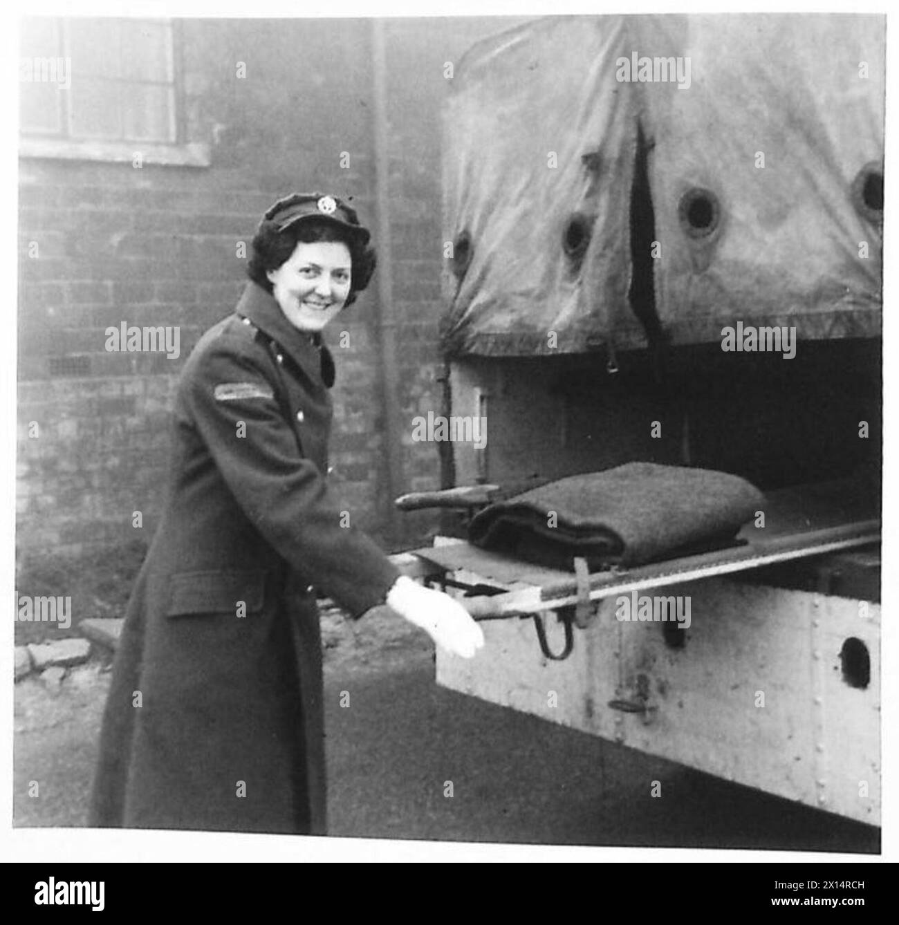 Pte. Margaret Johnson von der ATS trägt eine Trage aus ihrem Krankenwagen, ihre Hände sind von Rettungseinsätzen bandagiert. Stockfoto