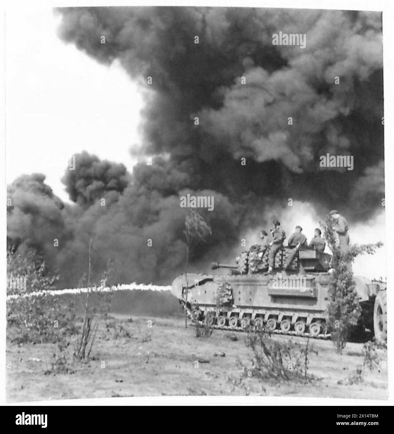 Krokodil-Flammenwerfer der 79. Panzerdivision, C-Geschwader, 12 Soldaten, 7. Königliche Panzerpanzer des Bataillons, besprühen den Boden im Konzentrationslager Belsen. Stockfoto