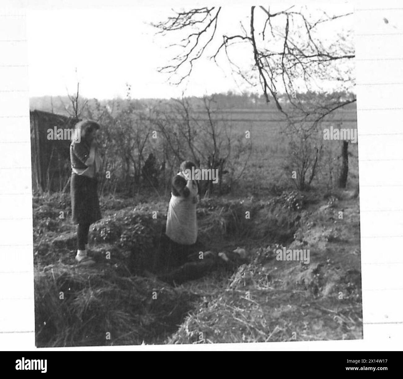 Ein Zivilist, der während des Angriffs auf Haustette an Schock starb, wird von seiner Frau und Tochter betrauert, während die Panzerdivision der Guards ihren Vormarsch fortsetzt. Stockfoto