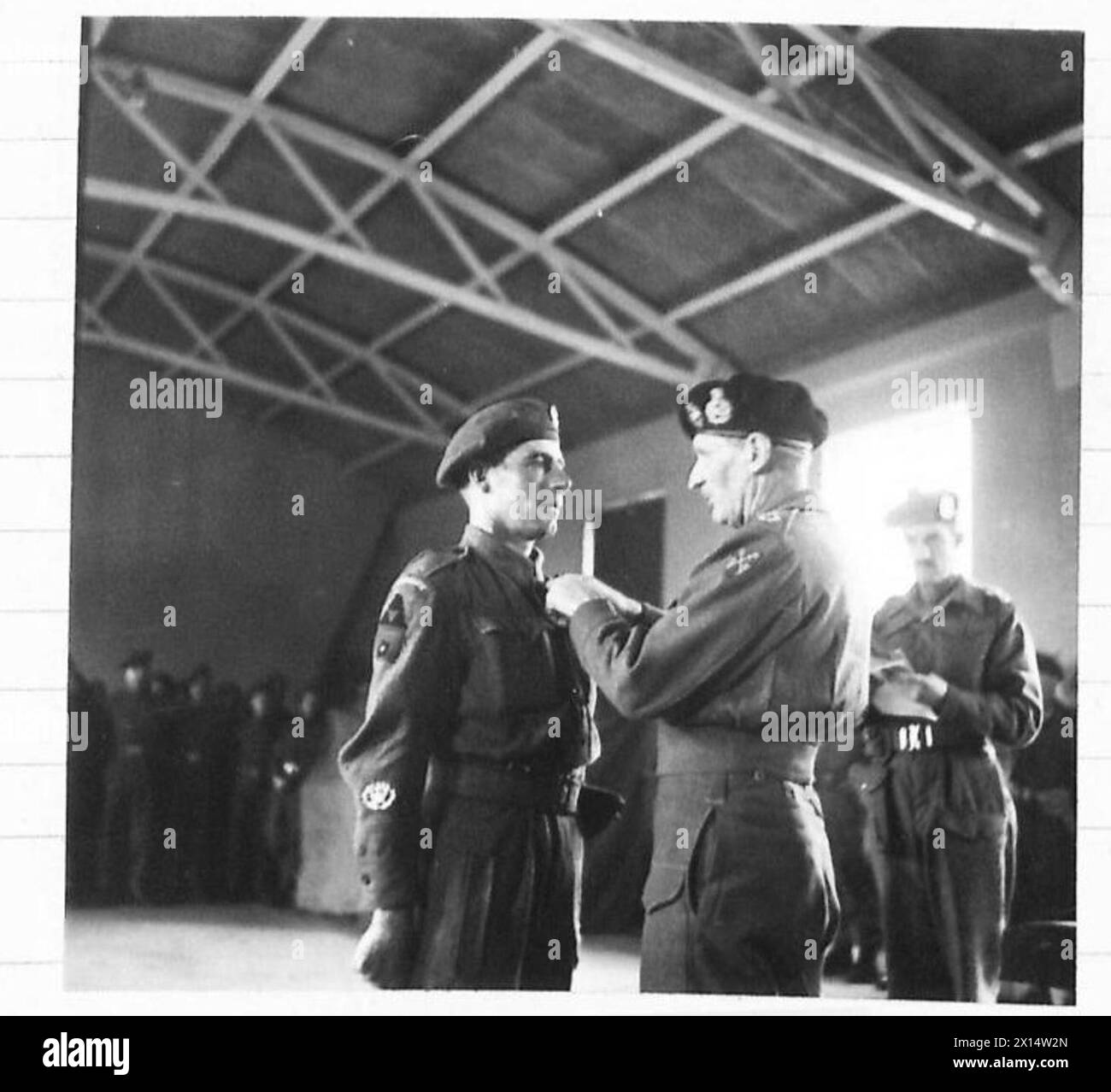 CSM G.H. Webb vom 2. East Yorkshire Regiment erhält die Distinguished Conduct Medal (DCM) und die Military Medal (MM) von Feldmarschall Montgomery während einer Amtseinführung der 3. Division. Stockfoto