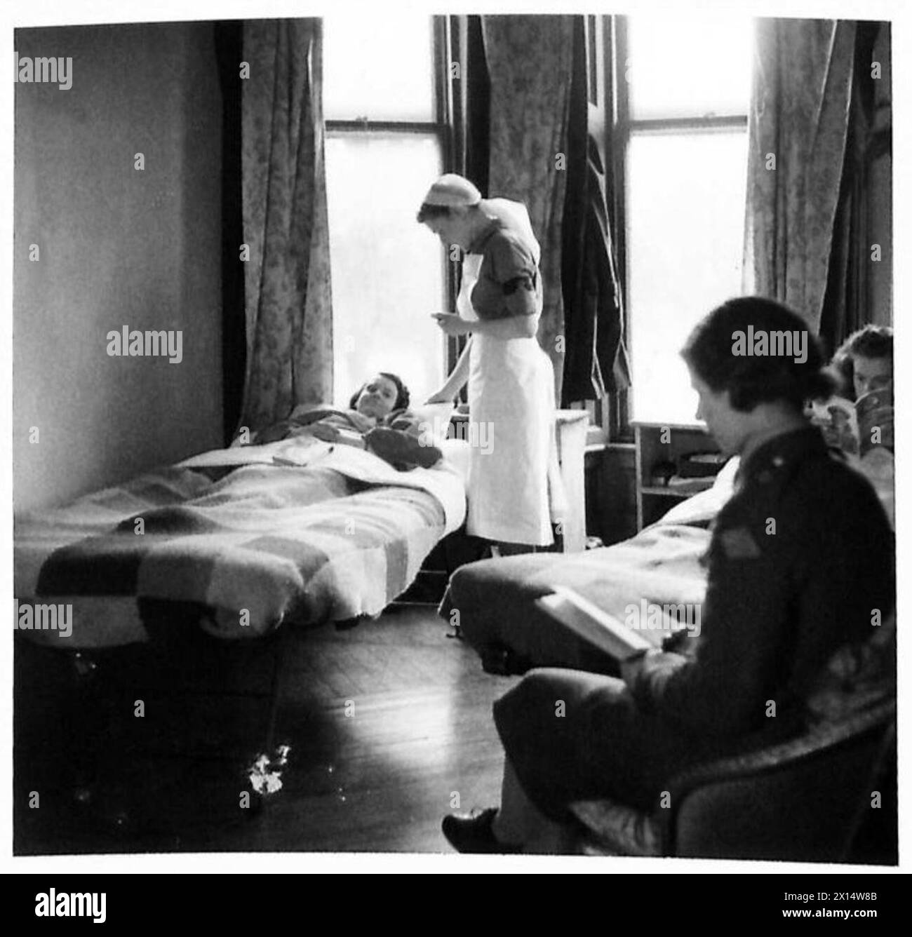 Ein Anti-Aircraft-Sanitäter behandelt ein Mädchen des Hilfsgebietes unter Aufsicht der britischen Armee mit einer Armverletzung. Stockfoto