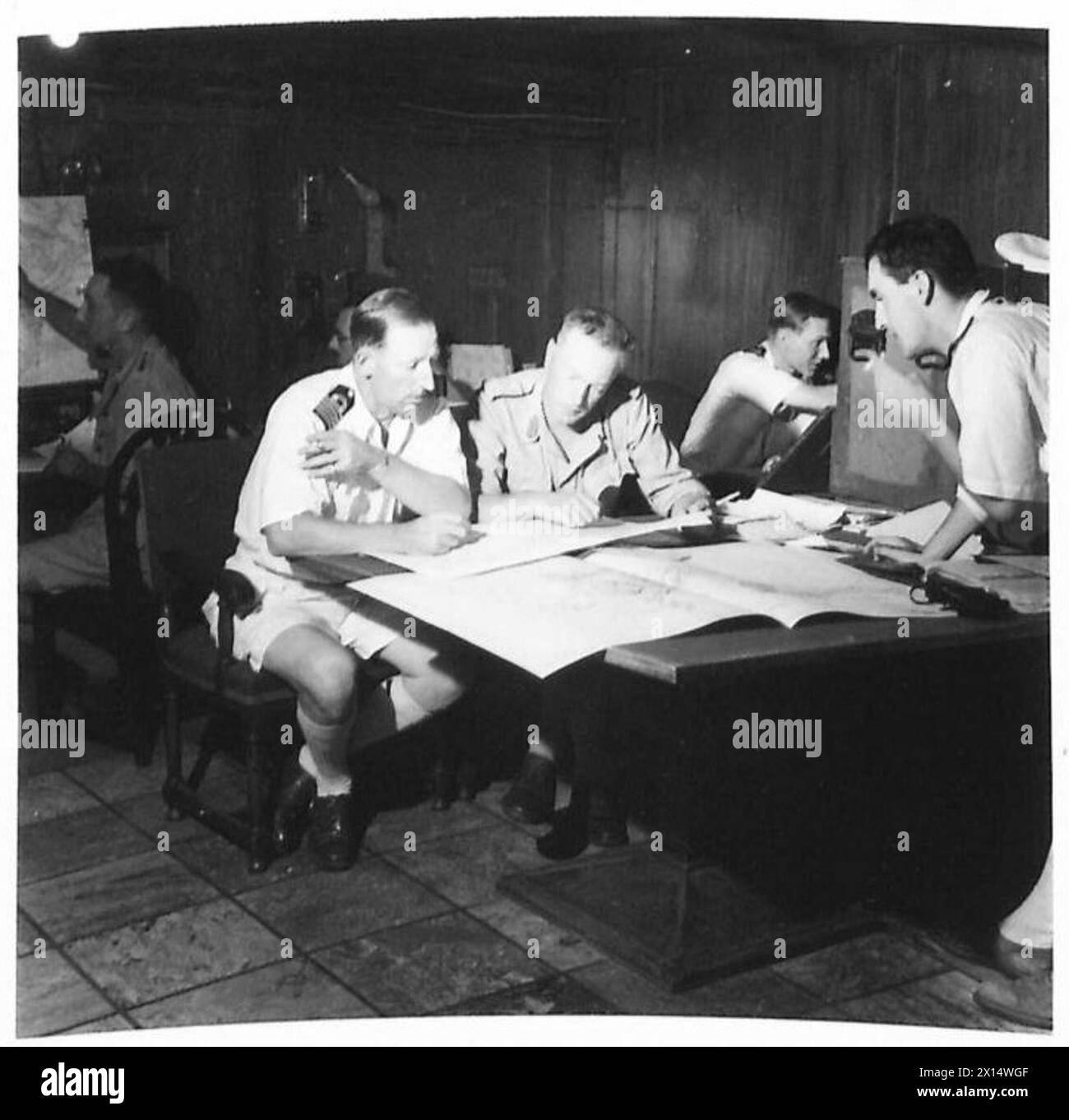 An Bord der Winchester Castle während der Invasion Siziliens kontrolliert der Raum der Brigade CPS Landungs- und Strandoperationen, wobei hochrangige Offiziere der Brigade 151 an Tischen sitzen. Stockfoto