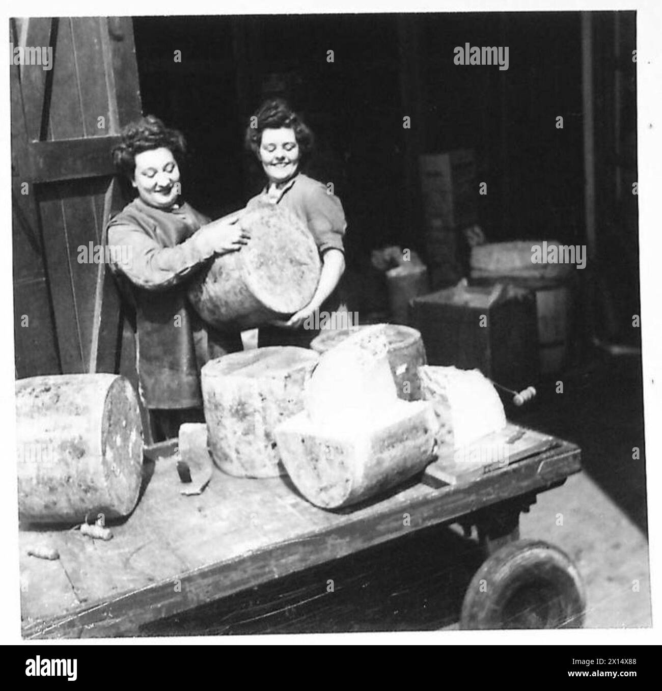 Private Stella Glynn und Lance Corporal Dorothy Briggs, Mitglieder des Auxiliary Territorial Service, schnitten große Käsesorten in Exeter und Blackburn, um ihre Pflichten im Umgang mit Lebensmitteln und im Militärdienst zu veranschaulichen. Stockfoto
