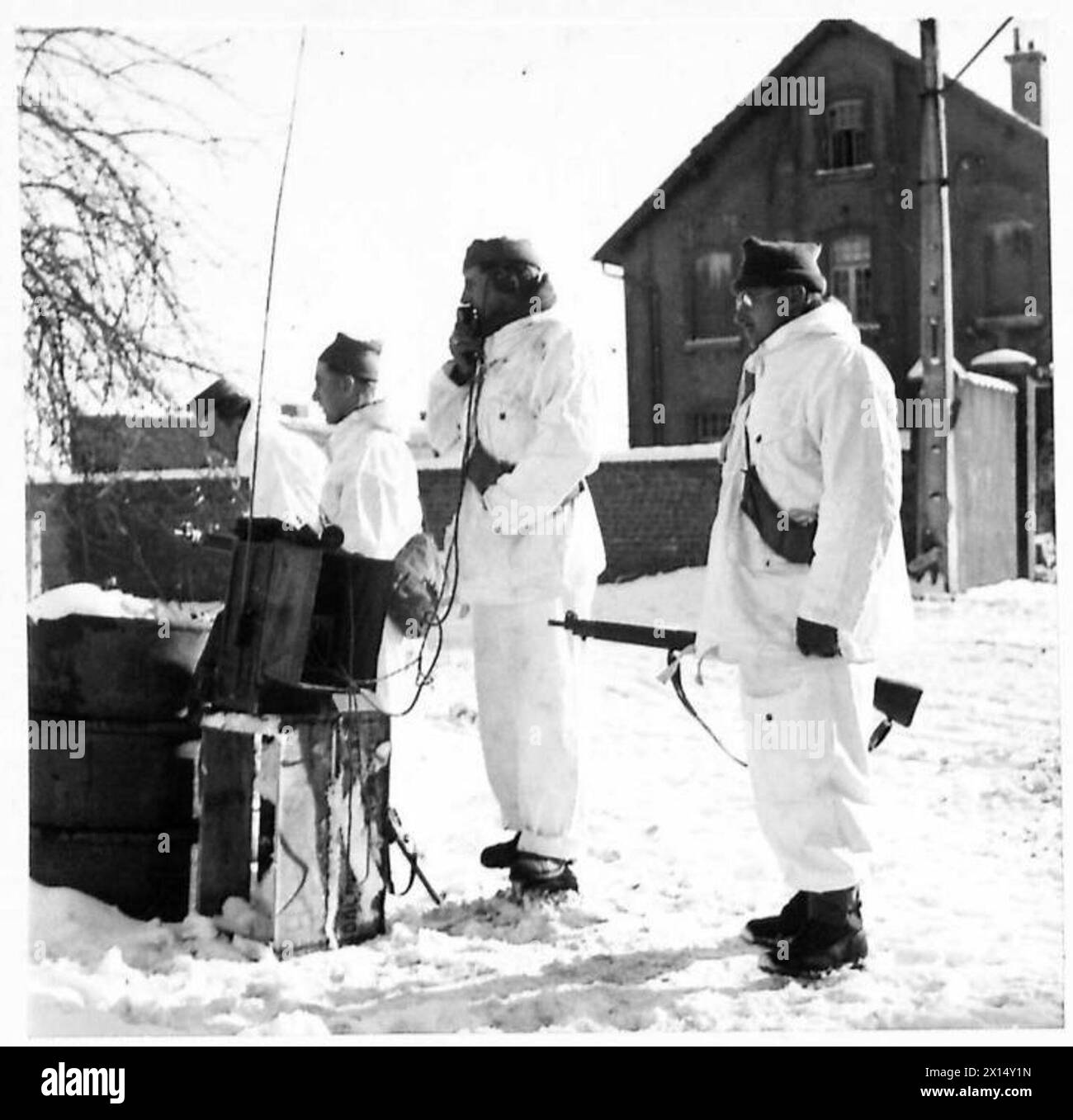 Der private Johnson von den Camerons Highlanders der 5. Queen betreibt während einer Aufklärungspatrouille ein Funkgerät an der Kreuzung von Champlon. Alle Soldaten tragen weiße Tarnanzüge. Stockfoto
