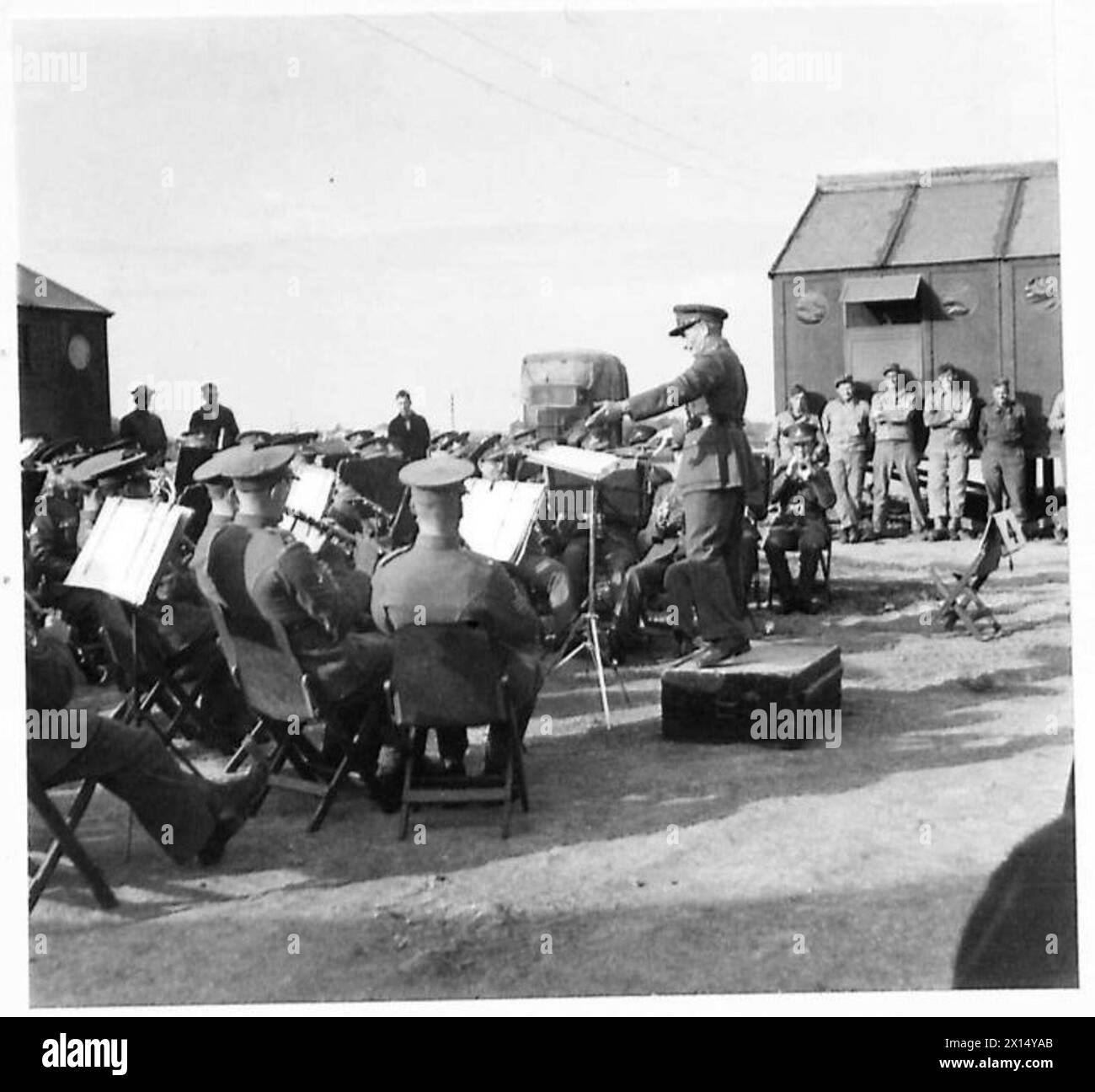 Die Band der britischen Armee tritt im 79. Amerikanischen Krankenhaus in Nordafrika auf und unterhält Patienten, Krankenschwestern und Ärzte, darunter PFC. Paul H. Day, ein US-Mediziner, der bei der Evakuierung der Verwundeten in Italien verletzt wurde. Stockfoto