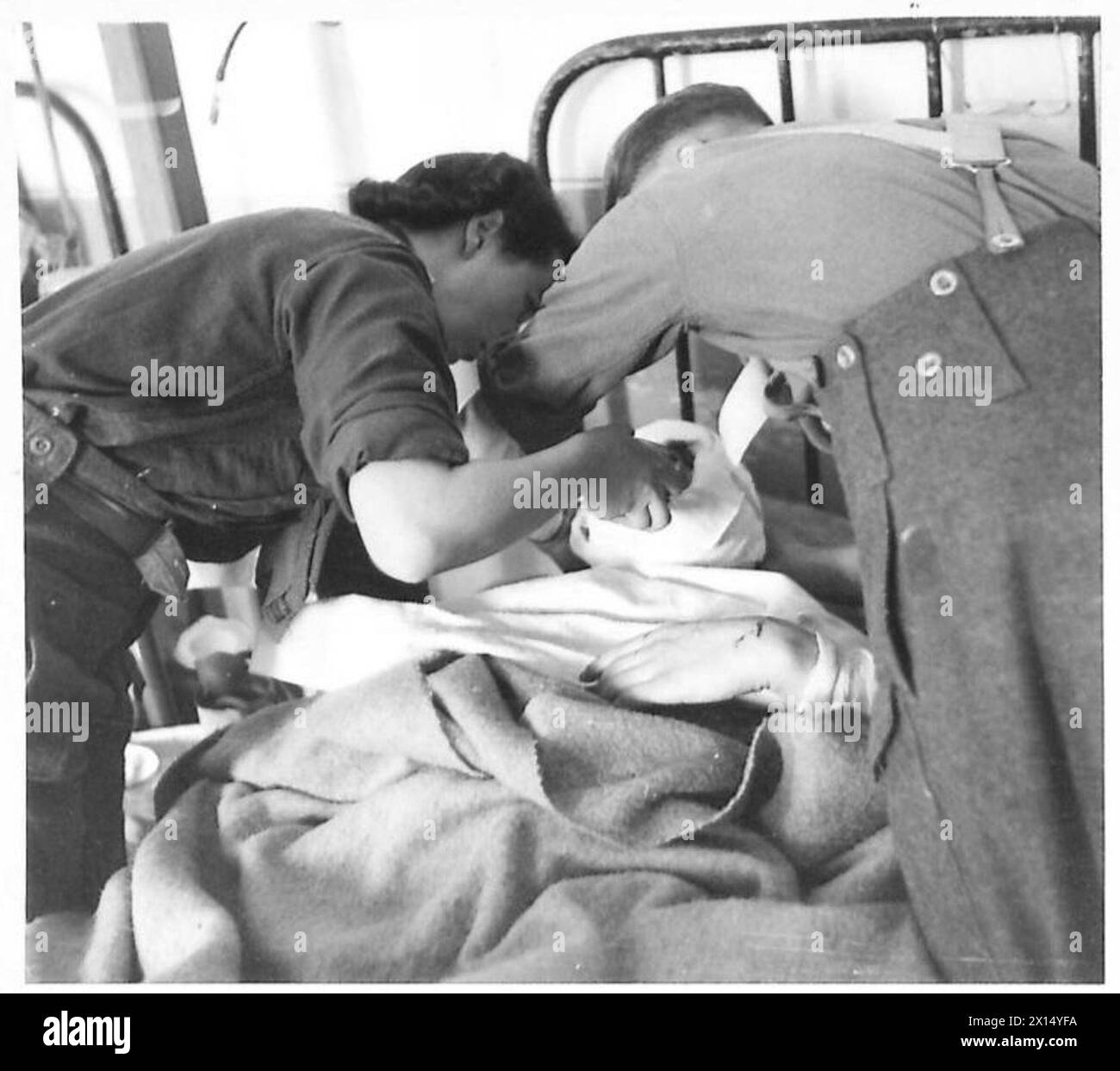 Schwester Gibson, eine Krankenschwester der Achten Armee in Italien, wird gezeigt, wie sie privat Munro ernährt, was die medizinische Versorgung und die Unterstützung der Truppen in Einsatzgebieten veranschaulicht. Stockfoto