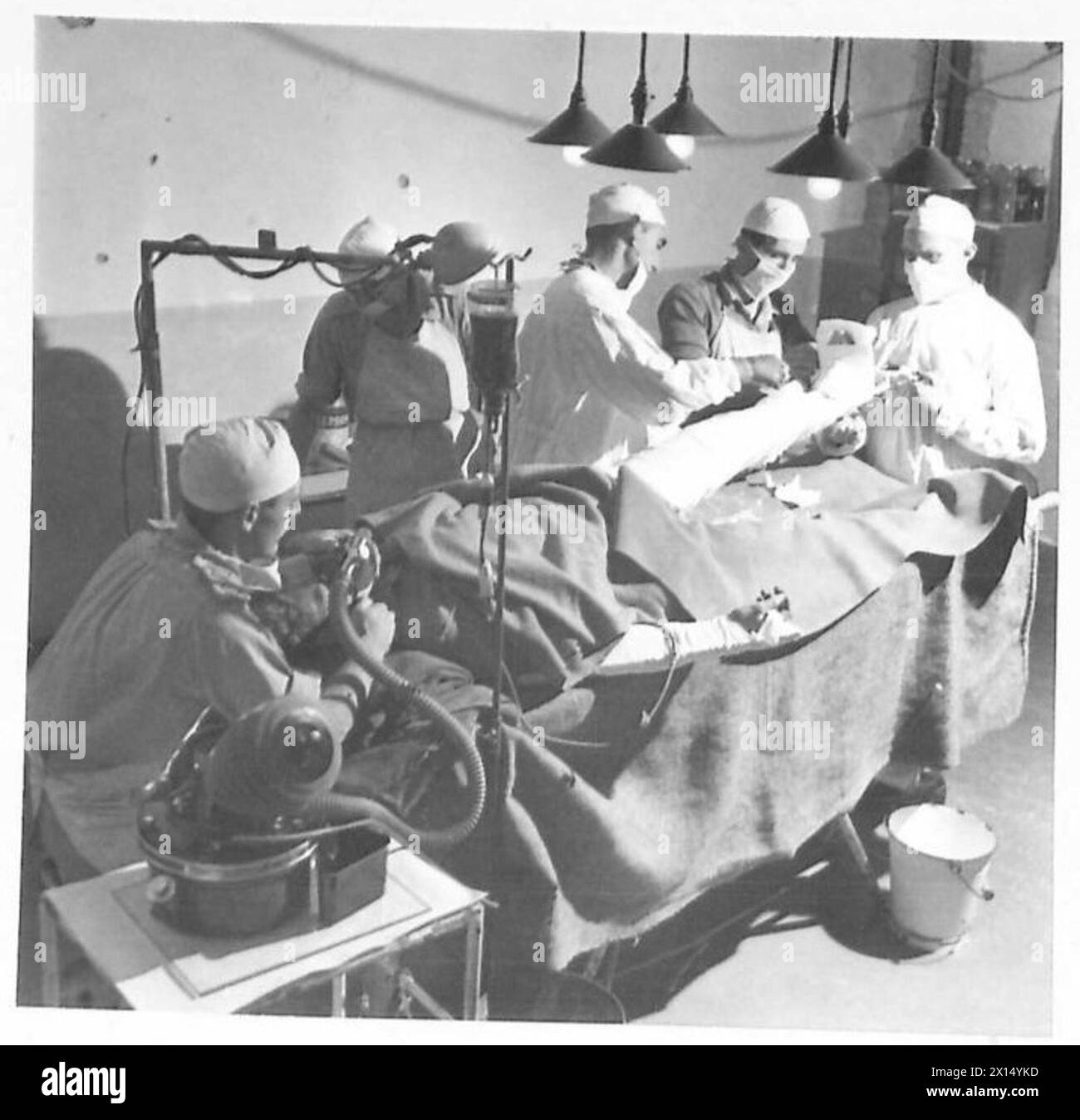 BLUTTRANSFUSION IM VORDEREN BEREICH - Eine frische Blutflasche wurde angebracht, der Chirurg reinigt das zerschlissene Bein des Patienten British Army Stockfoto