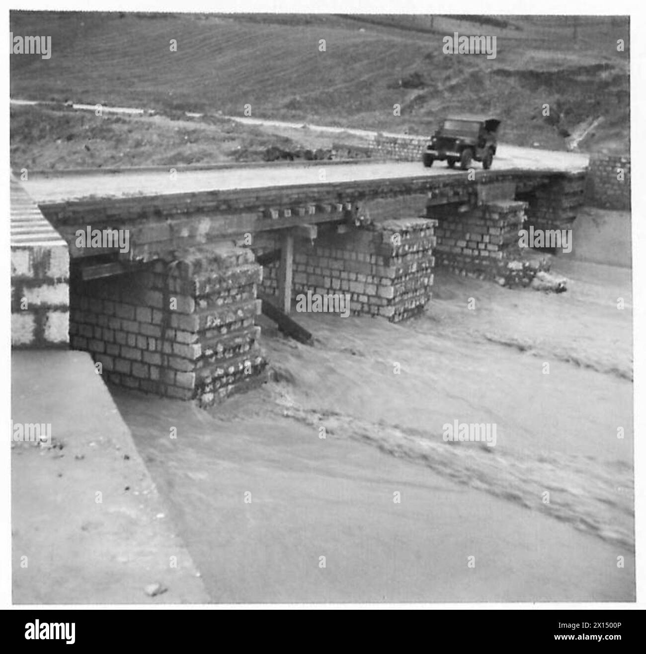 ITALIEN: HERBSTFLUTEN VERURSACHEN STRASSENSCHÄDEN - Route 90 bei Grottanminarda, M.R. N.884769. Cl.70 provisorische Brücke, gebaut, um Hochwasser am „Engpass“-Standort am Fluss Ufila standzuhalten. Maximale Hochwasserstände haben gerade die Brücke der Britischen Armee überdeckt Stockfoto