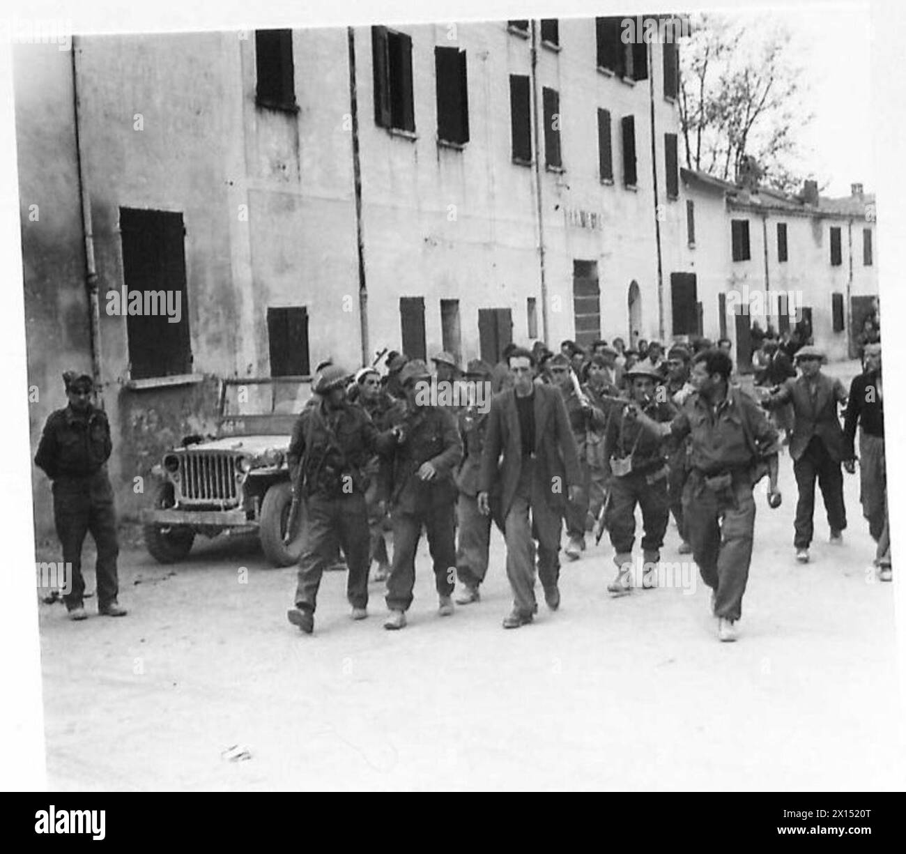 Während des Vormarsches der Achten Armee bei Lavezzola nehmen Partisanen eine Gruppe deutscher Soldaten gefangen und bringen sie ein, während die Armee sich auf die Überquerung des Flusses Reno vorbereitet. Stockfoto