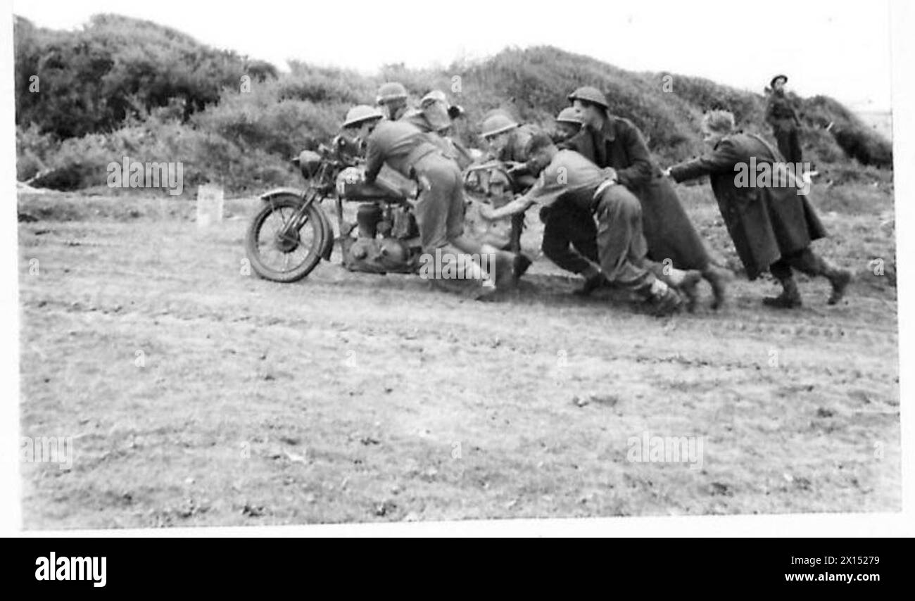 Während der Landung der Alliierten südlich von Rom stößt ein Motorradfahrer auf Schwierigkeiten auf einer steilen Straße, unterstützt von mehreren Helfern. Stockfoto