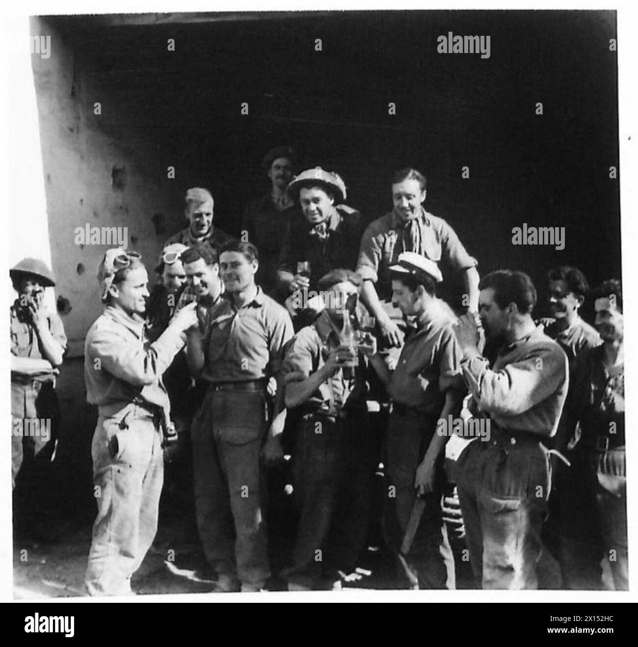 Soldaten der achten Armee halten an, um in Portomaggiore zu trinken, nachdem sie die Stadt während der Operationen betreten haben. Stockfoto