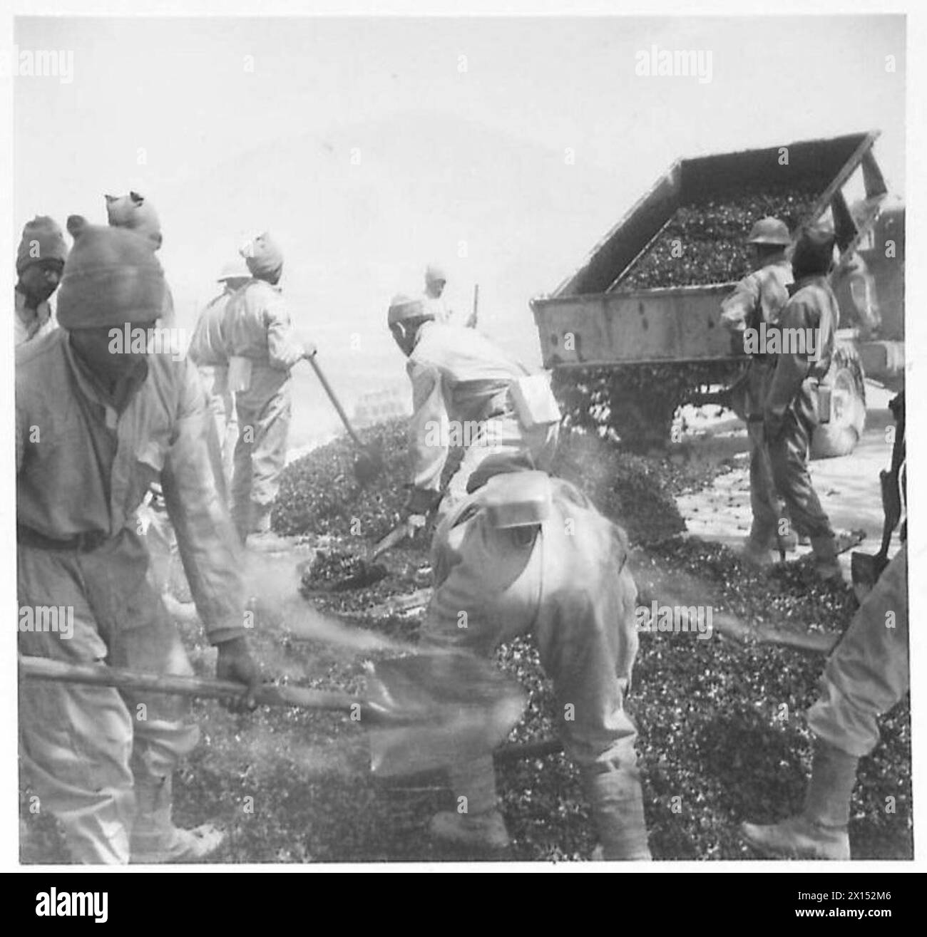Geteerte Steine werden von Mitarbeitern der Fünften Armee auf die Straße gelegt, um Transportwege zu reparieren und zu pflegen. Stockfoto