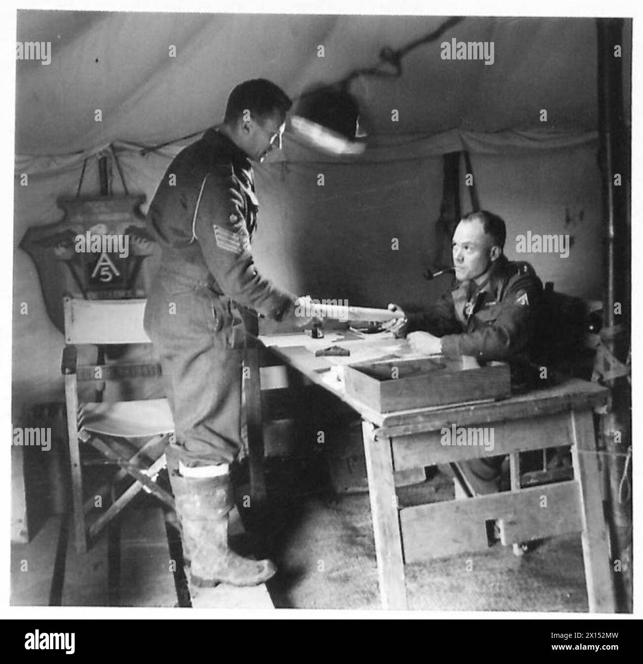 S/Sgt. S.C. Johnson von den South African Survey Engineers reicht eine Rückverfolgung an den Offizier der Survey Company, Major G.E. Marriott, für die Produktion eines Verteidigungsaufdrucks ein. Stockfoto