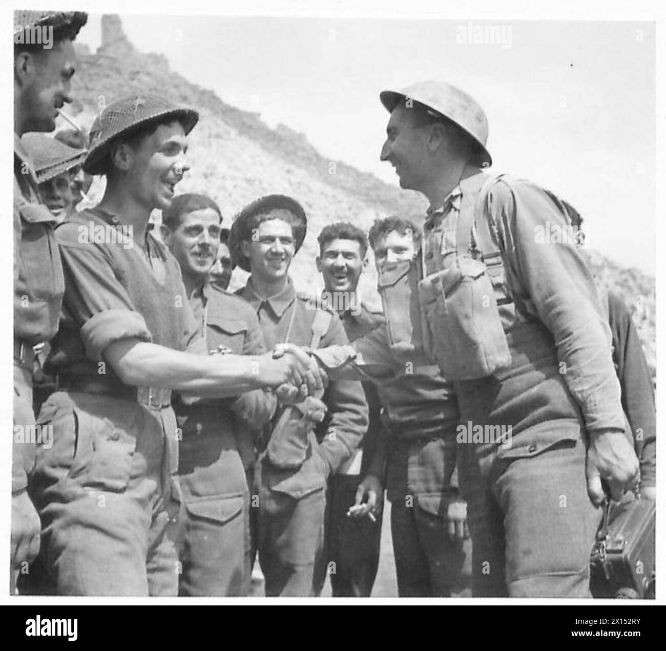 ITALIEN : DIE GEFANGENNAHME VON CASSINO - nachdem sie 10 Tage in Cassino "nebenan" gelebt haben, treffen sich zwei einheimische Männer zwischen den Ruinen. Sgt. Französisch - Army Film Unit - von West Stanley Co. Durham, schüttelt die Hand mit Gdsmn F. Grise von 8 Pemberton Crescent, Durham British Army Stockfoto