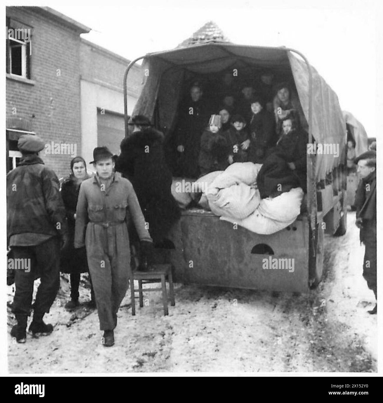 Deutsche Zivilisten werden in 3-Tonnen-LKW von den Vorwärtslinien nach Tuddern transportiert, um sich während der Operationen der britischen Armee im Sittard-Dreieck in neue Häuser umzusiedeln. Stockfoto