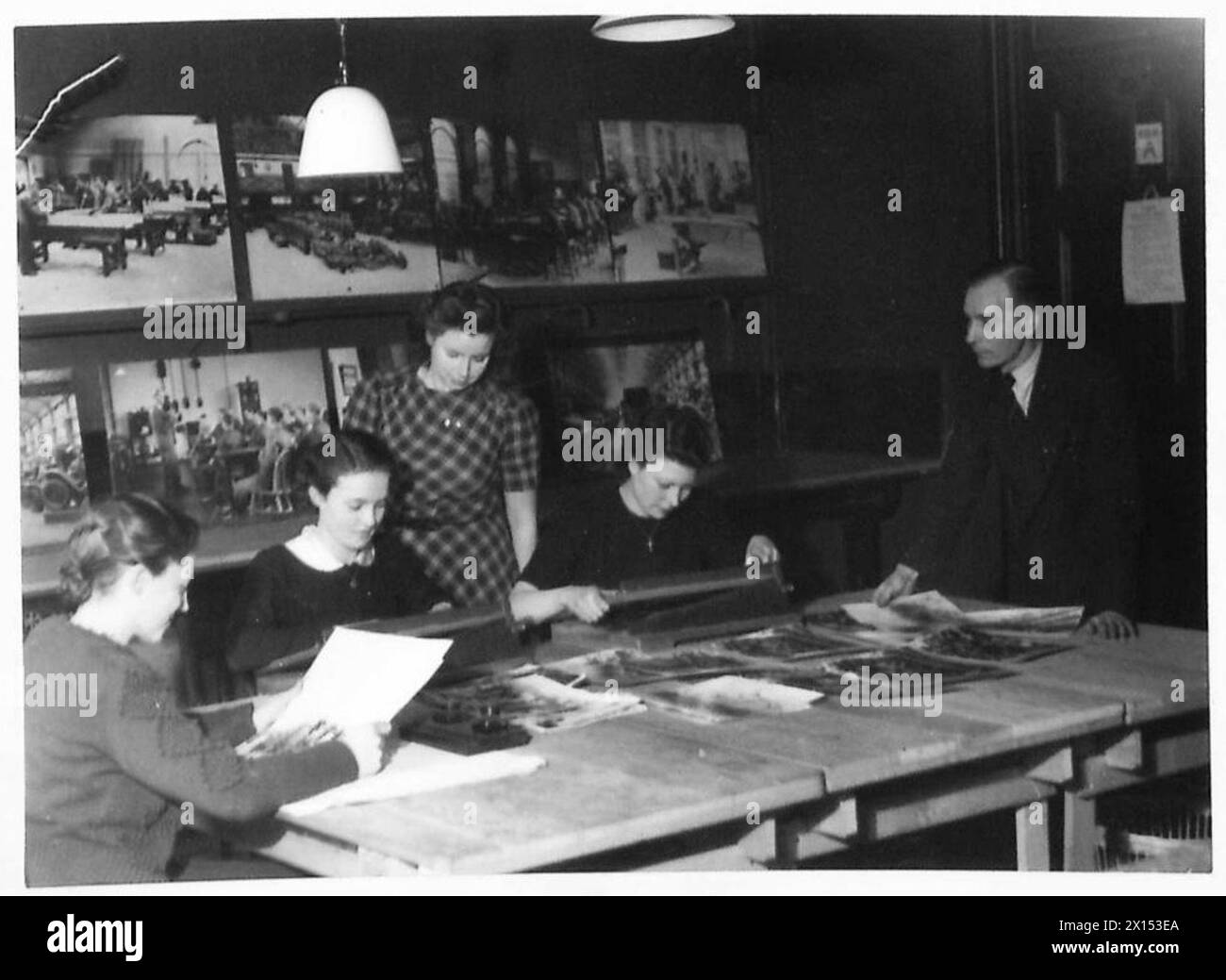 Die Fotoeinheit des Kriegsministeriums ist mit dem Zuschneiden, Sortieren und Organisieren von Fotoabzügen für offizielle Aufzeichnungen beschäftigt. Stockfoto