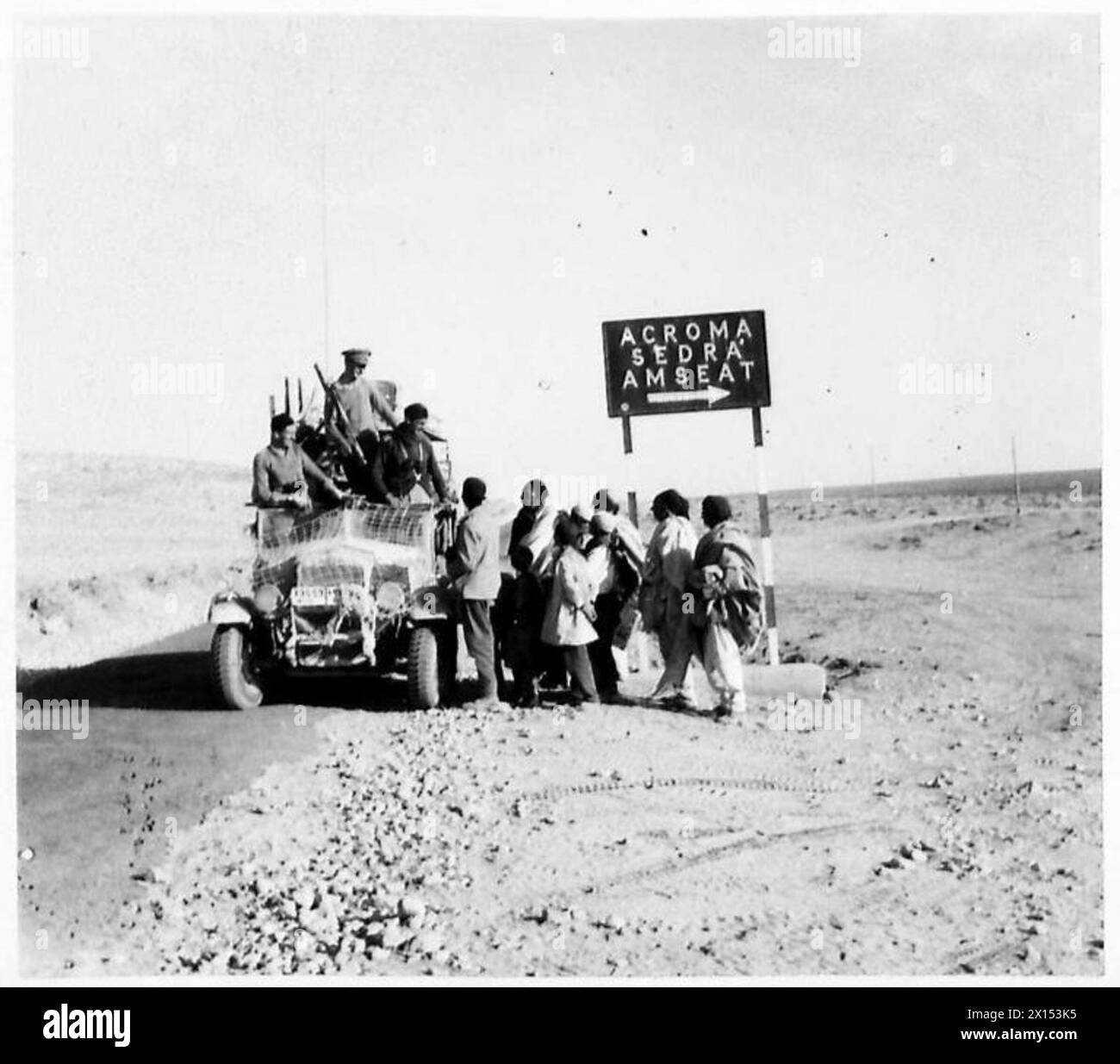 Britische Offiziere rücken entlang der Tobruk-Derna-Straße in der Westwüste vor und erhalten Informationen von befreundeten Beduinen, die die Militäroperation unterstützen. Stockfoto Britische Offiziere rücken entlang der Tobruk-Derna-Straße in der Westwüste vor und erhalten Informationen von befreundeten Beduinen, die die Militäroperation unterstützen. Stockfoto