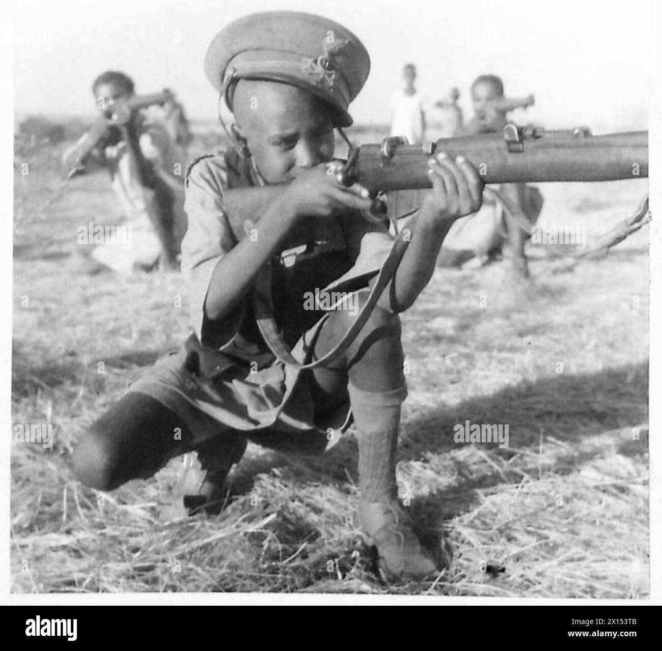 Äthiopische Krieger, einschließlich Väter, Söhne und Brüder, unterstützen britische Truppen, mit einem 14-jährigen Jungen, der die Mütze eines geschnappten italienischen Offiziers trägt. Stockfoto