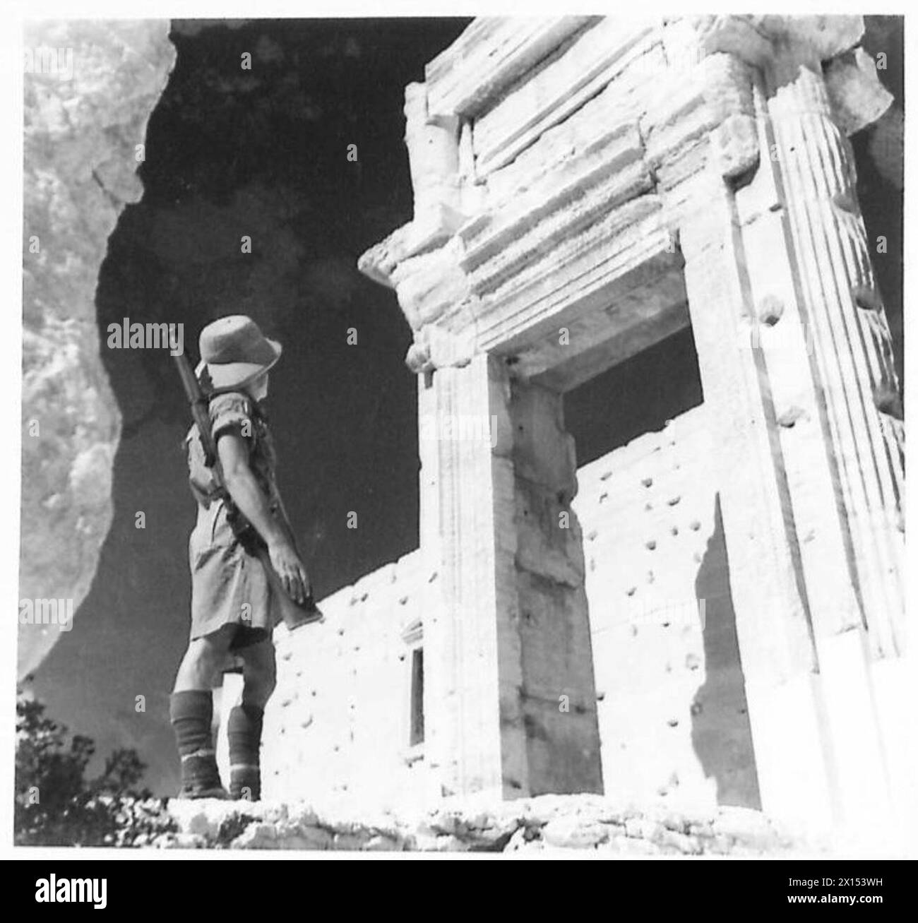 Ein britischer Soldat inspiziert Ruinen während der Besetzung Palmyras und dokumentiert dabei strukturelle Schäden und historische Überreste. Stockfoto