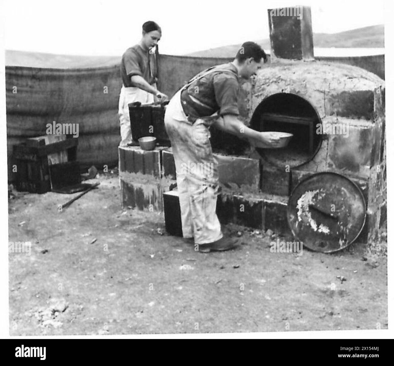 Eine Unfallbeseitigungsstation in Nordafrika nutzt einen großen Feldofen aus Benzindosen und Lehm als Teil von improvisierten medizinischen Operationen der British Army. Stockfoto