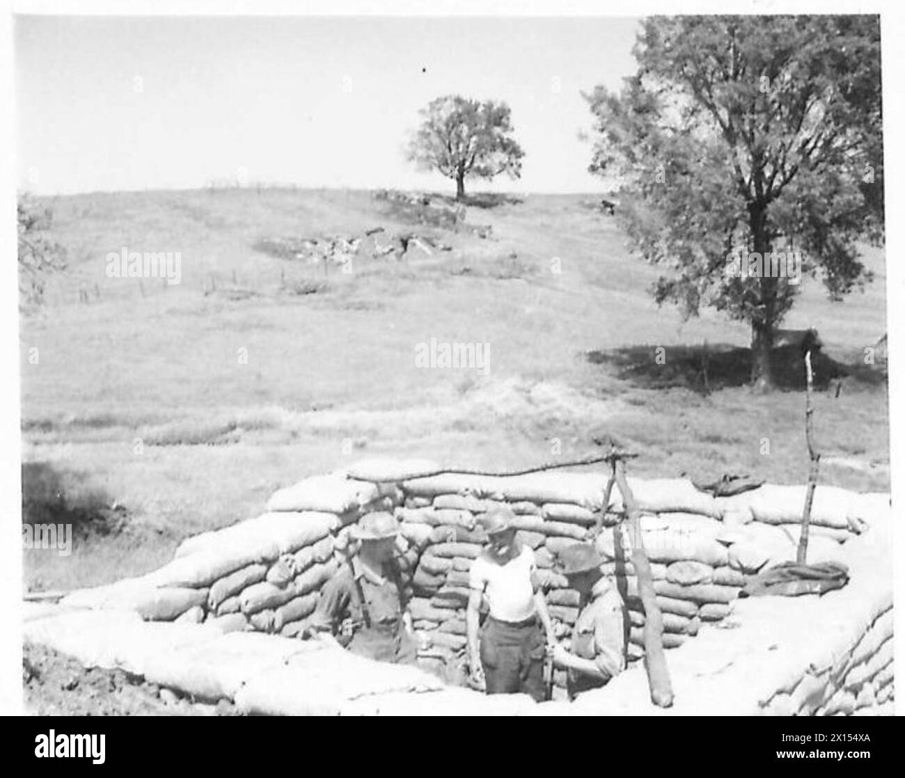 Lieutenants und Korporale der No.1 Squadron, 3rd Reconnaissance Regiment, befinden sich im Kochhaus am Anzio Brückenkopf; eine 88-mm-Granate landete in der Nähe, wurde aber von Sandsäcken umgelenkt. Stockfoto