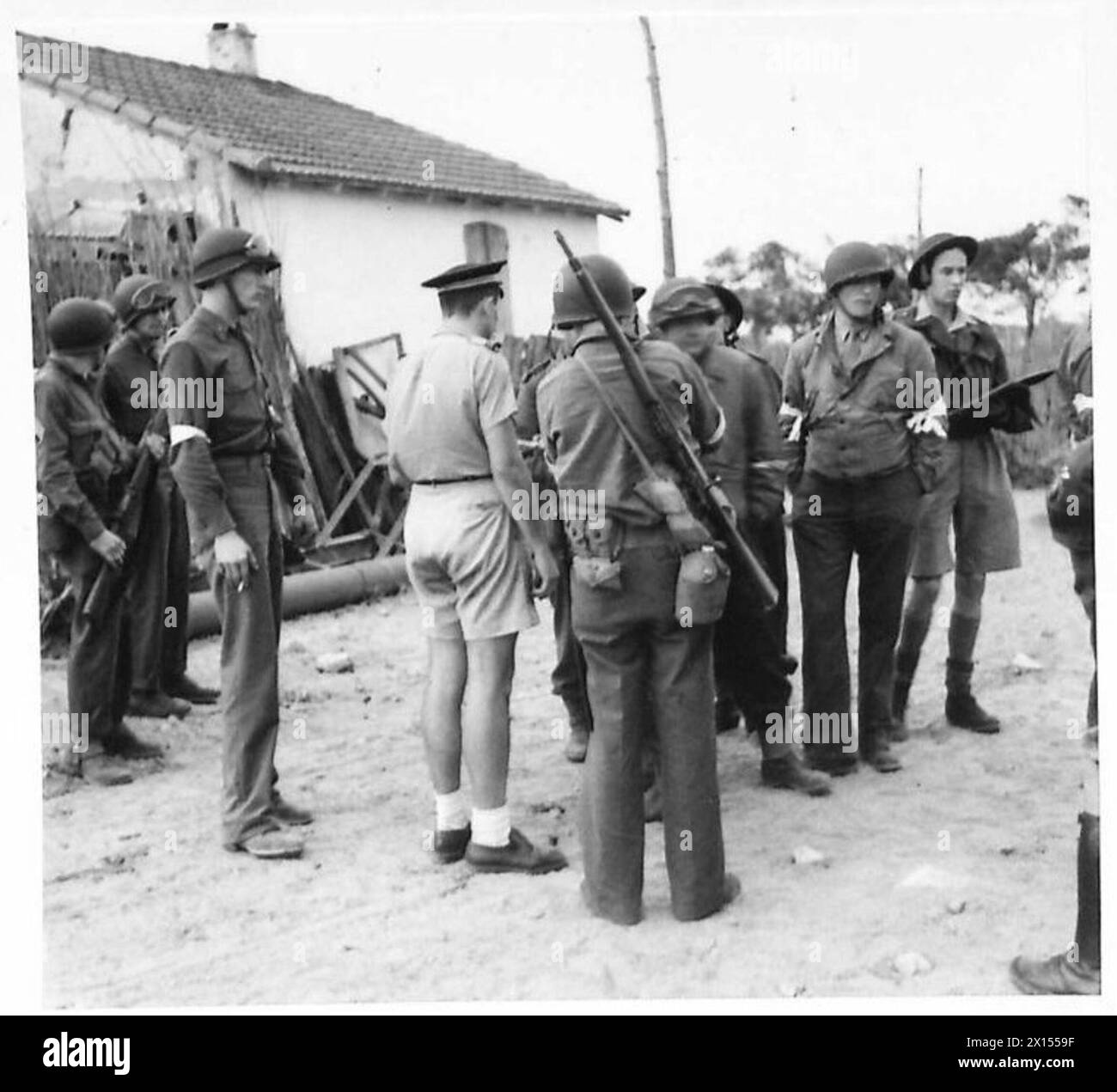 Truppen der 34. US-Infanteriedivision befragen am 9. November 1942 während der Operation Torch einen gefangenen Offizier der französischen Luftwaffe nahe dem Flughafen Maison Blanche in Algier. Stockfoto