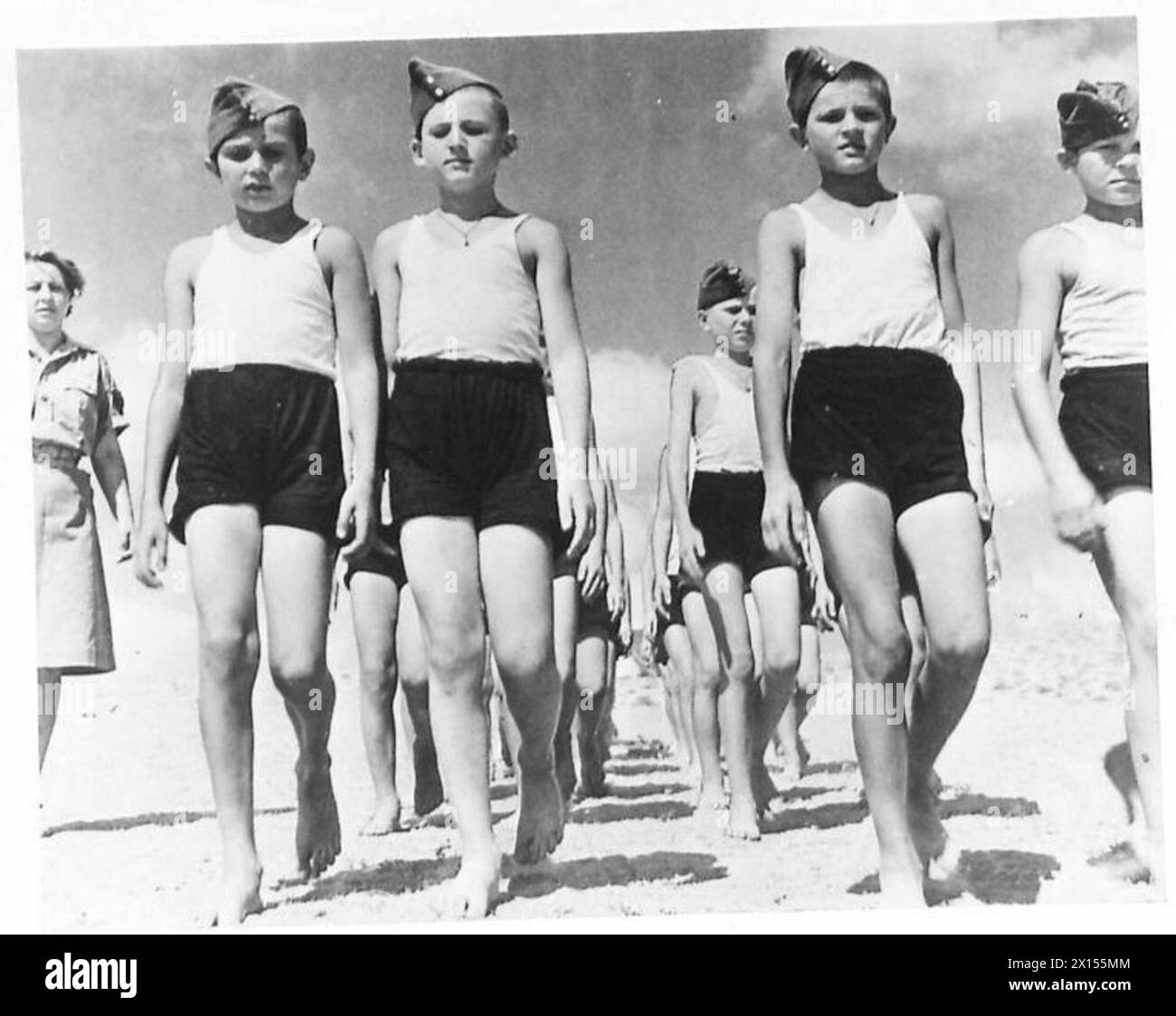 DIE POLNISCHE ARMEE IM NAHEN OSTEN, 1942-1943 - Eine Einheit von Jungen, die barfuß während einer Parade marschieren. Bewegung und frische Luft wirkten mit ihrem Körper Wunder und ermöglichten es ihnen, sich vollständig von den Not und dem Hunger des sowjetischen Gulag zu erholen. Nach der deutsch-sowjetischen Invasion Polens wurden viele Polen in verschiedene Lager im sowjetischen Gulag deportiert. Unter ihnen waren viele Jungen jeden Alters. Nach der Unterzeichnung des Sikorski-Mayski-Abkommens 1941 wurden viele Überlebende - Männer, Frauen, Kinder - freigelassen und über Persien aus der Sowjetunion nach Palästina evakuiert Stockfoto